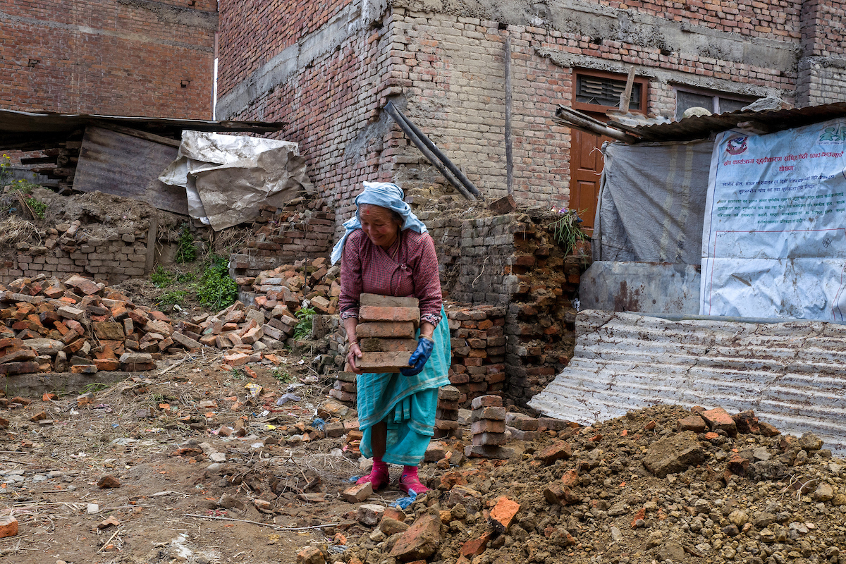 Kie Sari collects bricks that she salvaged from her destroyed home in Harisiddhi. Kie, 74, is a widow and has no one to help her, and she has not received help from the government. She spends her days collecting bricks that she cleans and piles up to be r