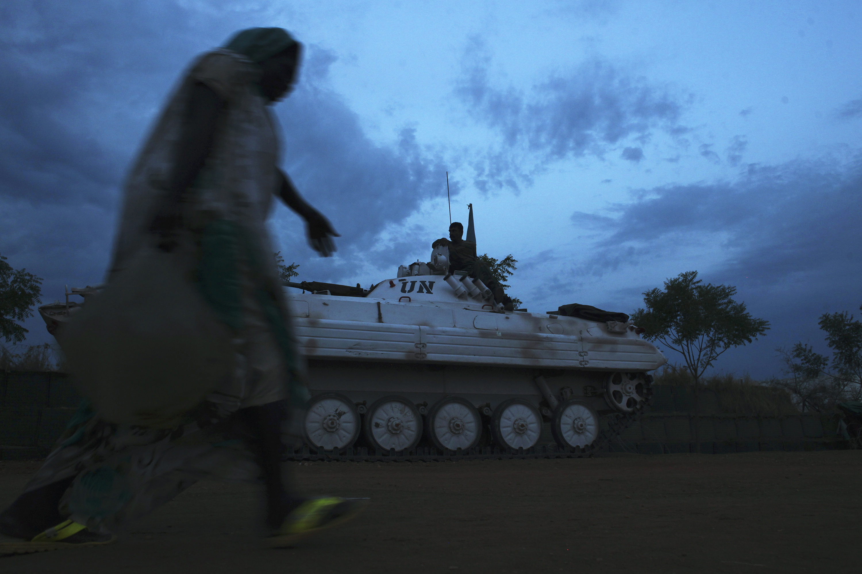 A woman passes by an armoured vehicle inside the UN camp in Malakal, South Sudan, which now hosts some 37,000 people displaced by war and fighting.