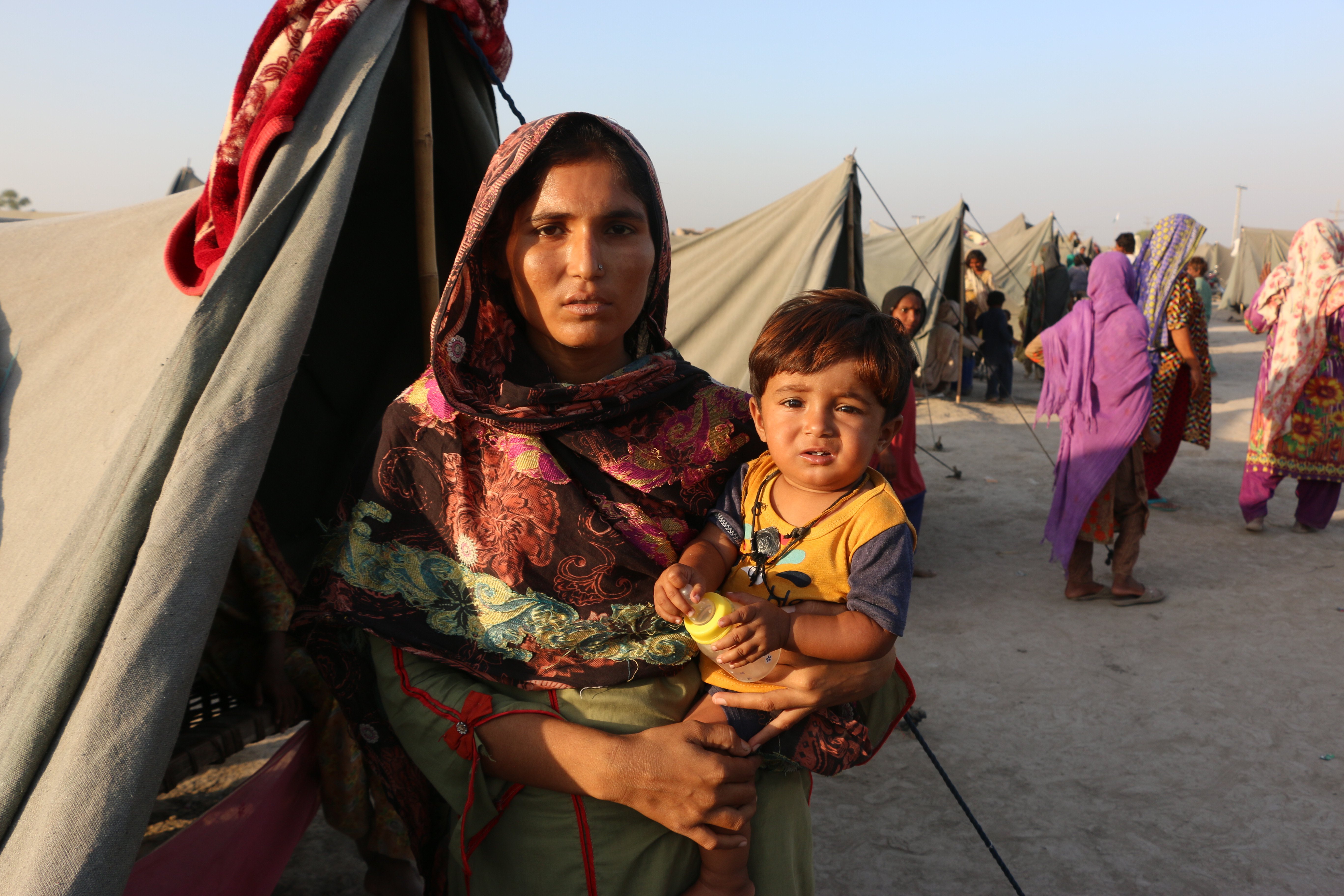 Arfa Landhar holds her daughter. After fleeing her flooded home in September, Arfa gave birth to a son who died just six days later due to inadequate medical treatment.