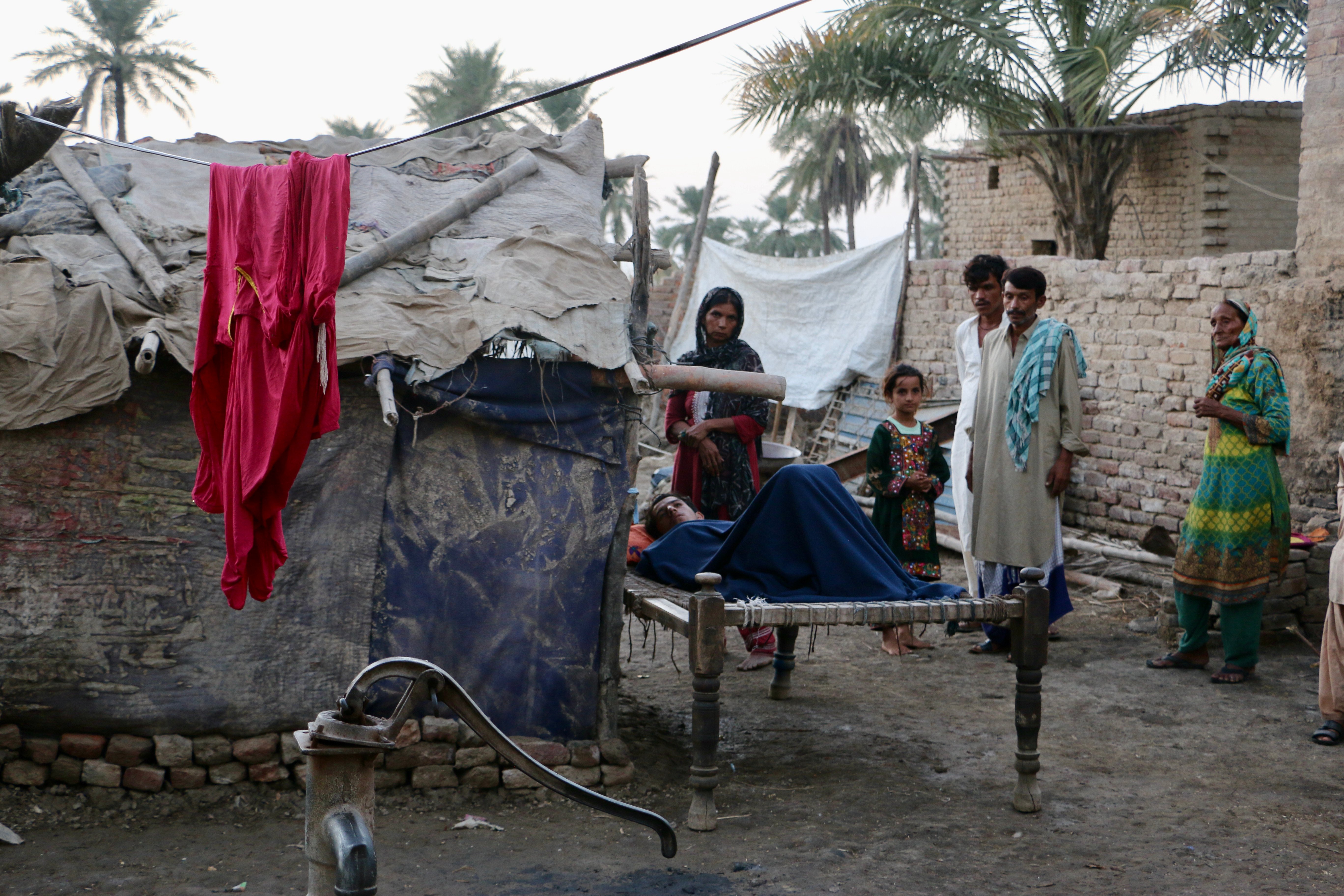 A malaria patient rests outside a home. Malaria and dengue have been on the rise as stagnant floodwaters create ideal mosquito breeding conditions.