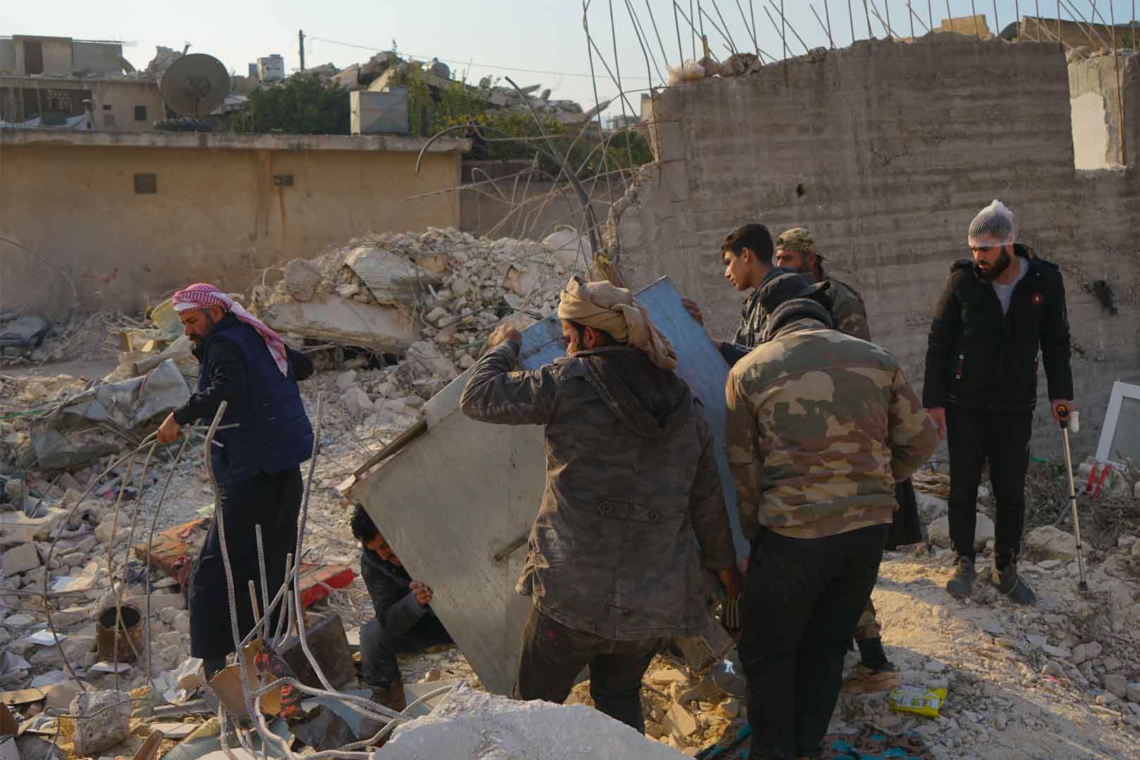 A group of men are cleaning up rubble that was created in the aftermath of the Syria-Türkiye quake in 2023.
