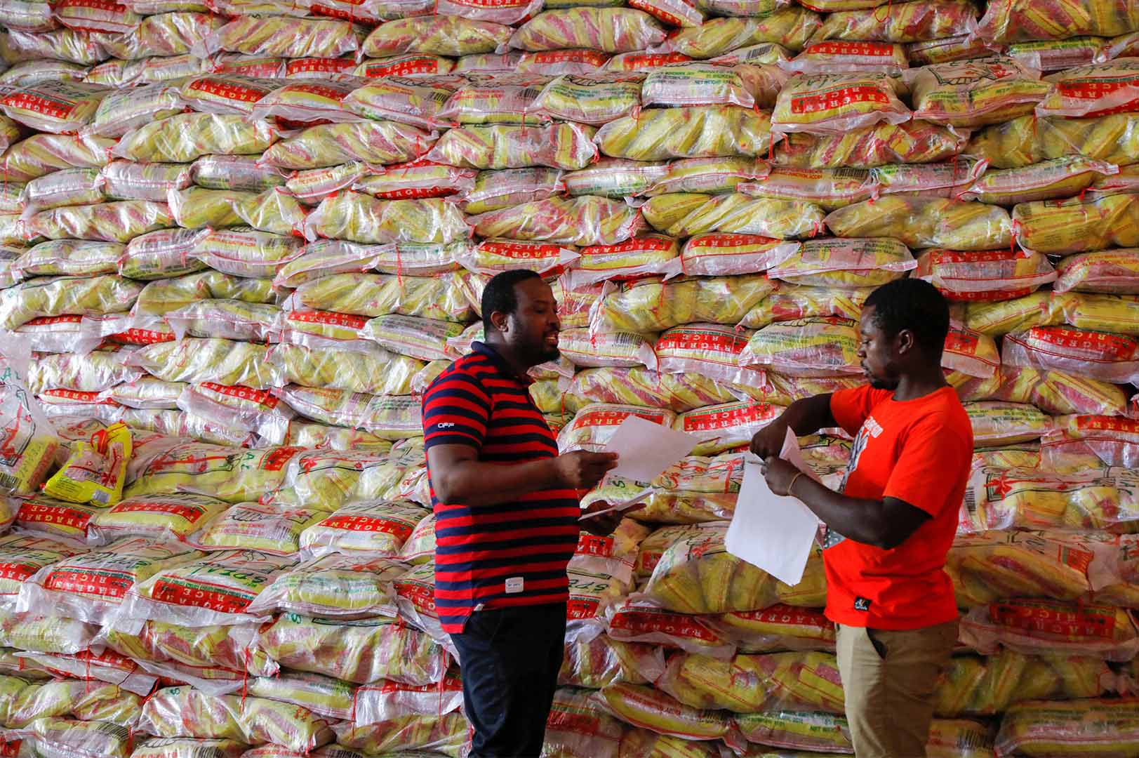 Chef Elijah Amoo Addo, and transport manager Ali Samed, 39, of Food For All Africa review stock information at a satellite warehouse in Offinso, Ghana June 7, 2022. Picture taken June 7, 2022. 