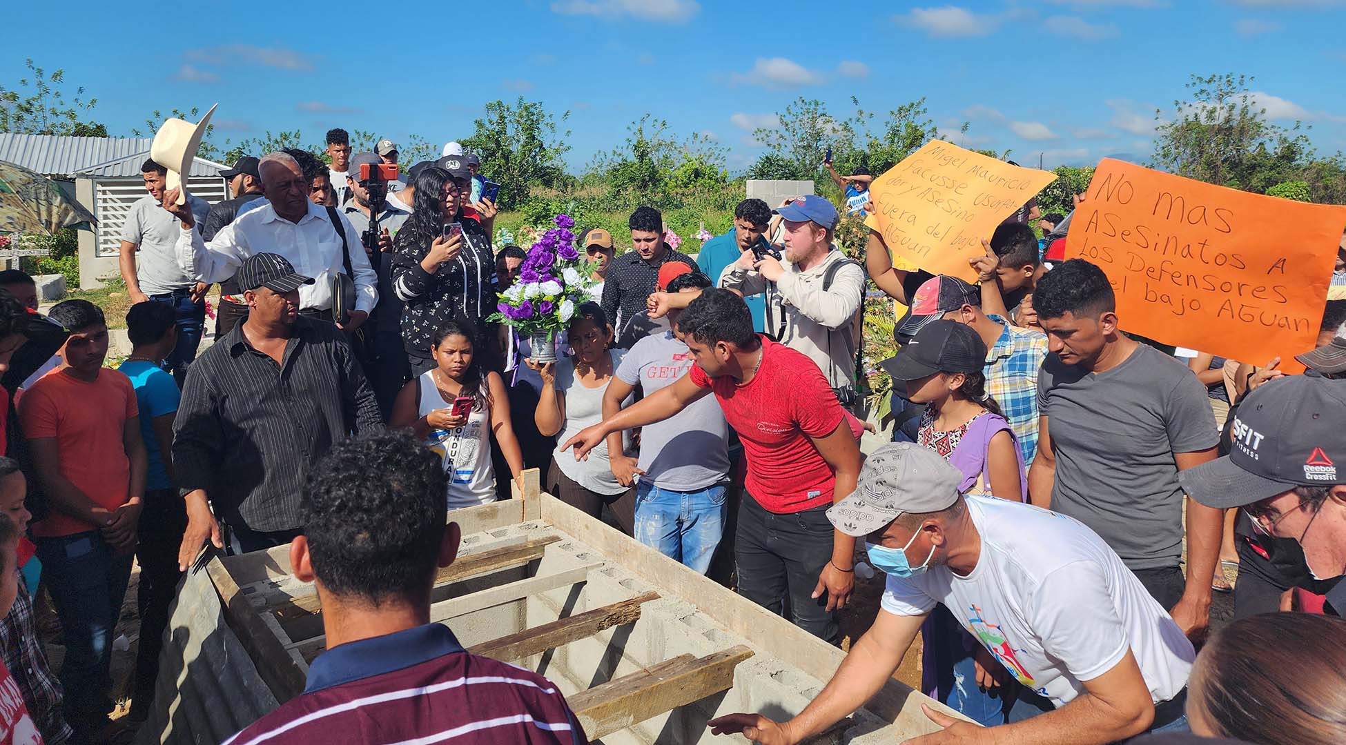 Pictured is the preparations for the burial for Omar Cruz in Honduras' Bajo Aguán Valley, in the Colón Department, now the most violent province of the country. Cruz, the leader of a cooperative physically occupying a palm plantation they allege was taken from them by agribusiness giants, had been assassinated by unknown gunmen alongside his brother in law in the town of Tocoa just two days before. A crows surrounds what looks to be the burial site. 