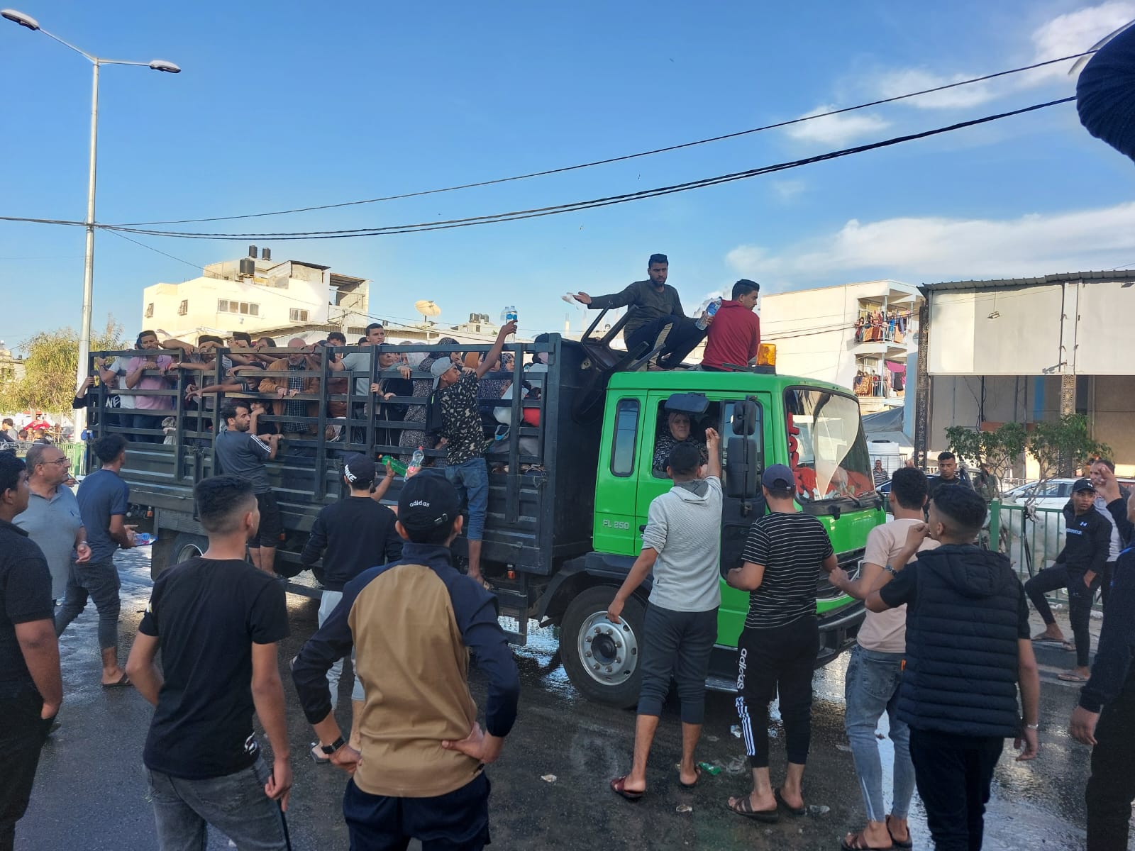 Palestinians forced to flee northern Gaza arrive at a crossroads near Khan Younis, a city in the southern part of the Gaza Strip are pictured on the back of a truck.