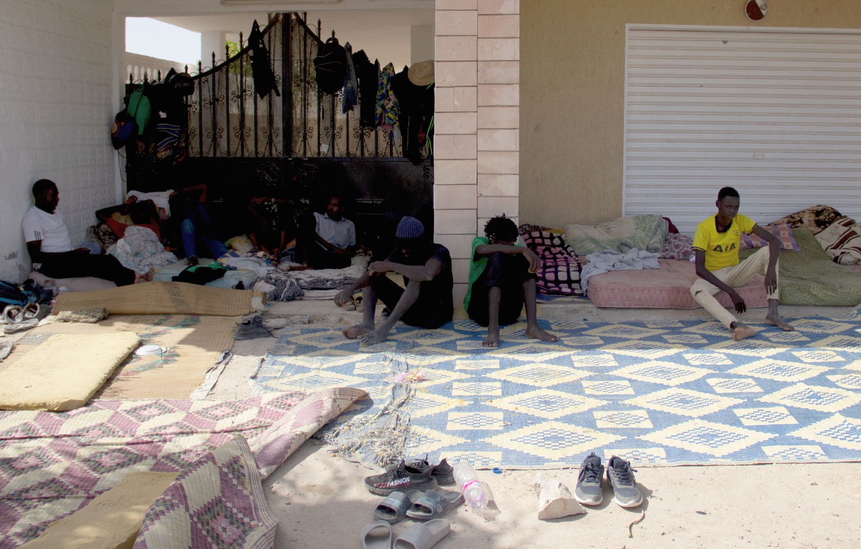 Sudanese sitting around in front of an abandoned building, Zarzis-Ben Guerdane highway (Zarzis, 18 Sept 2023)