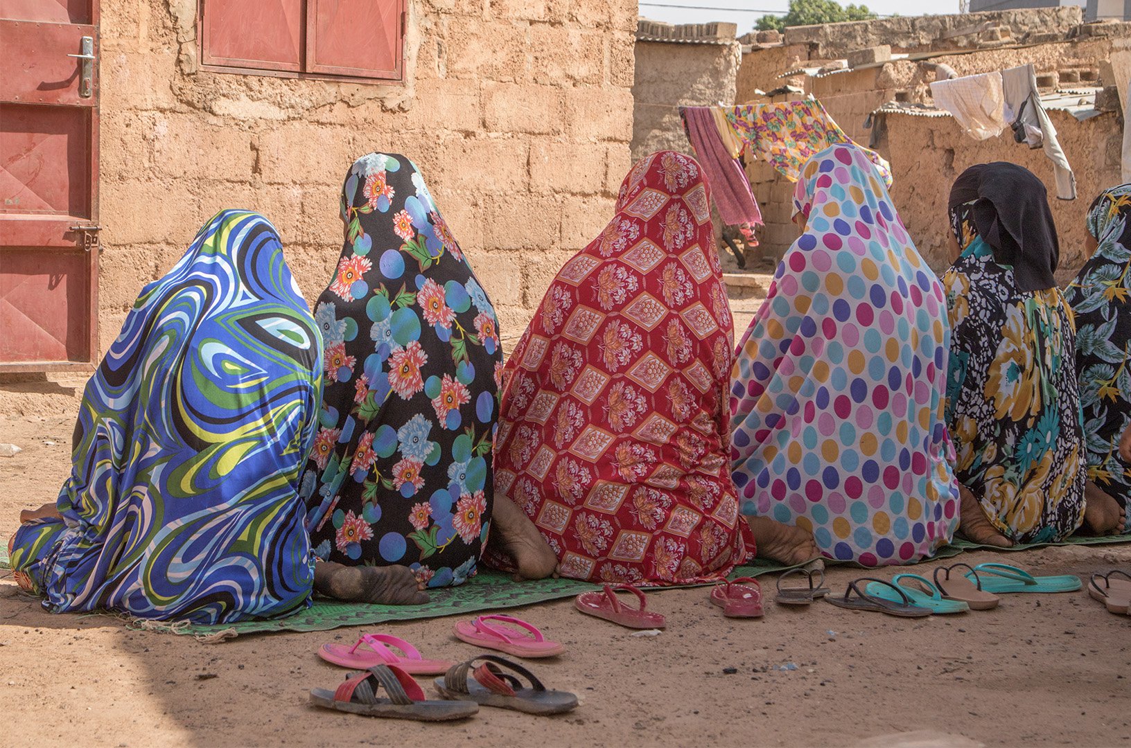 A group of people are are sitting in line facing away from the camera.