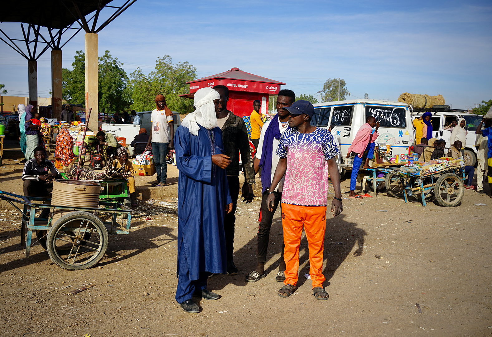 Boubacar Halilou speaks to three other people at the bus station in Agadez.