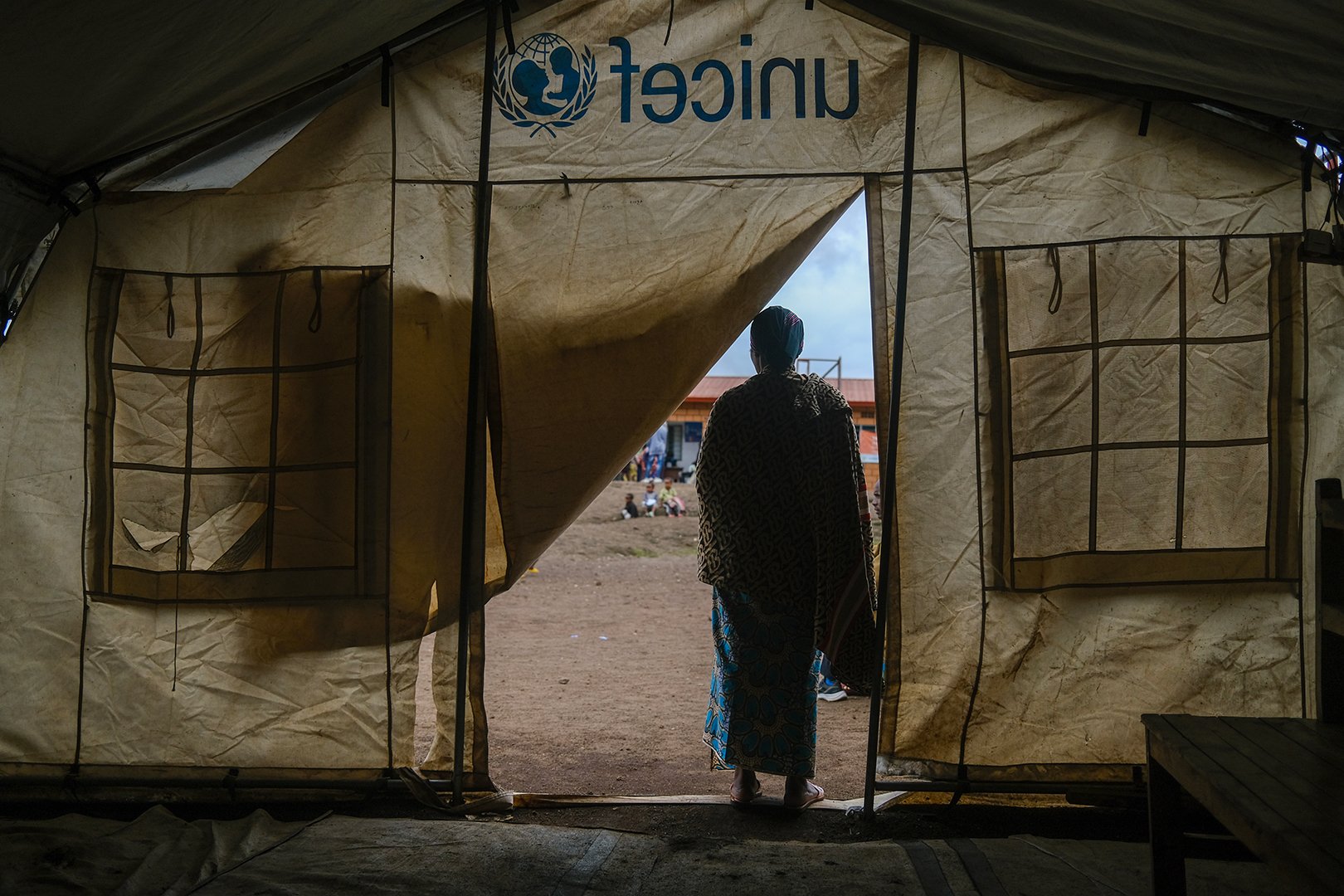 We see the silhouette of a Congolese Tutsi woman who said she was targeted by the Nyatura militia, as she stands by the entrance of a tent at the Nkamira transit centre in western Rwanda.