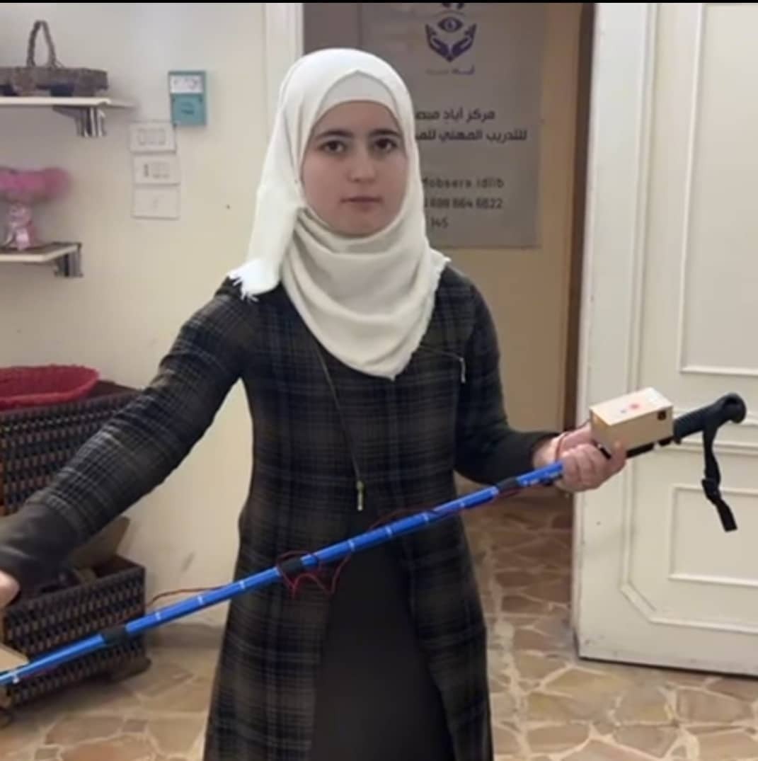 A young woman holds a walking stick for visually impaired people.