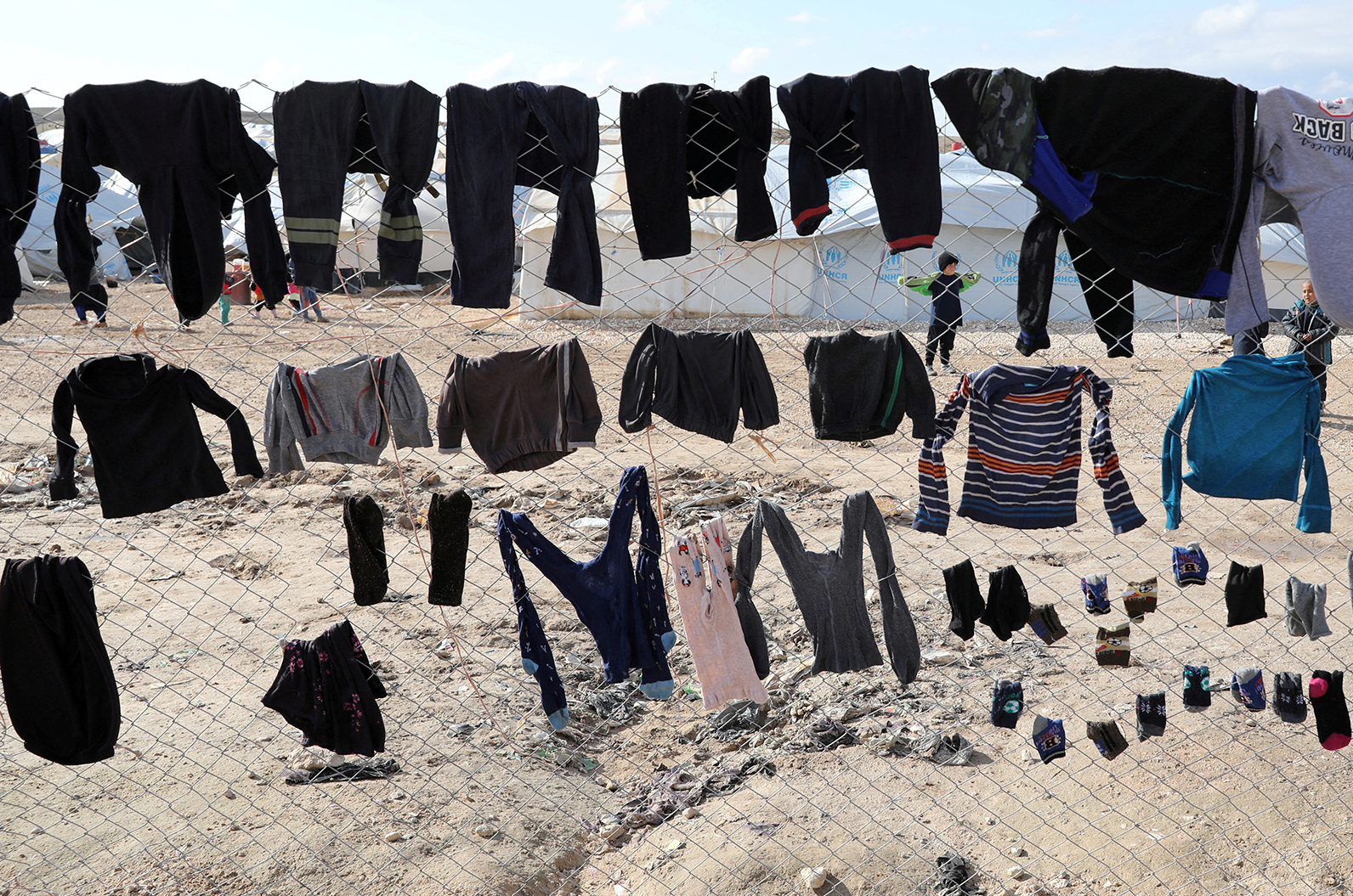Various clothing pieces of laundry are hung up on a fence in al-Hol in January 2020. 