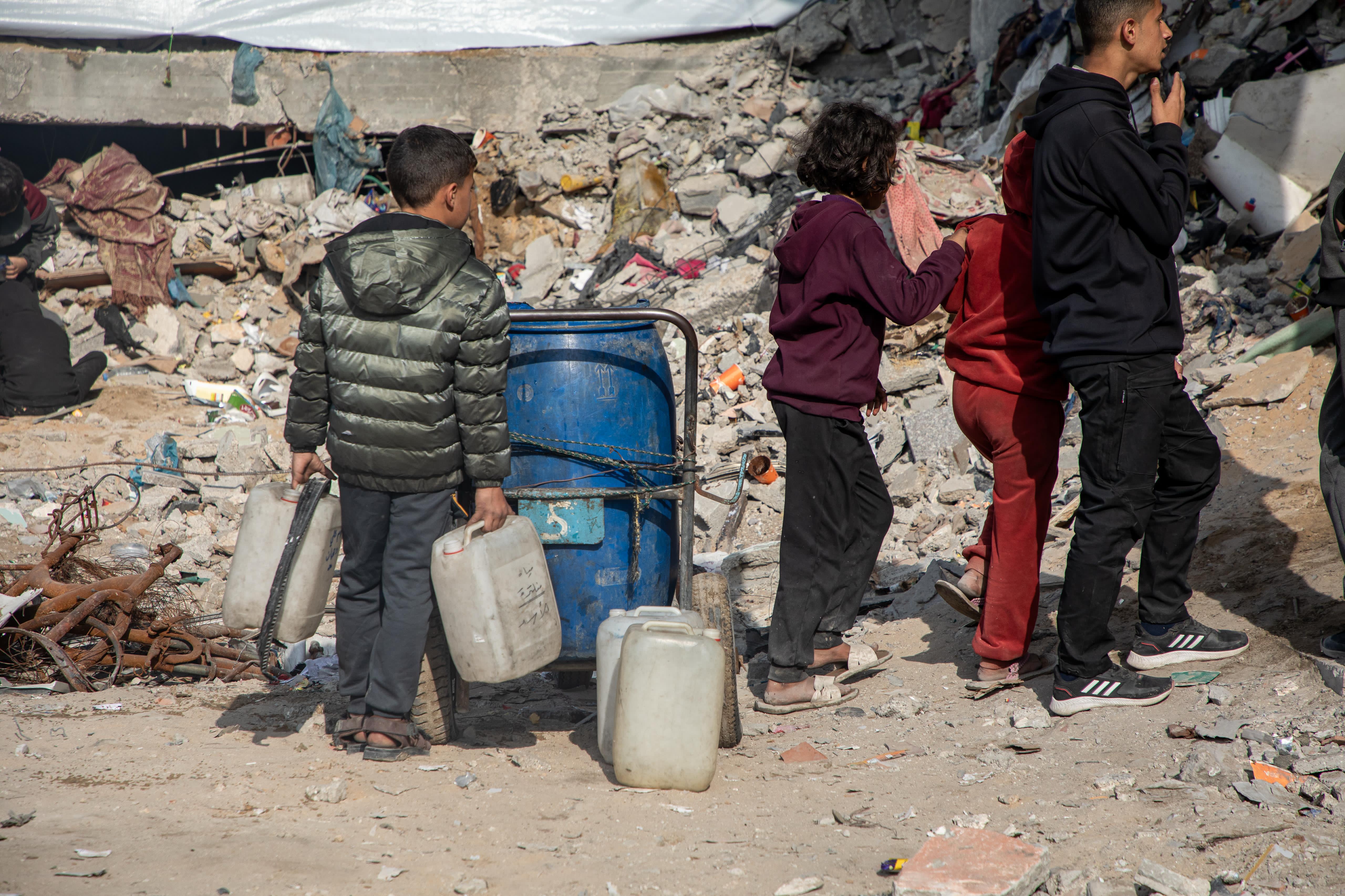 Children collecting water in Deir al-Balah, Gaza.
