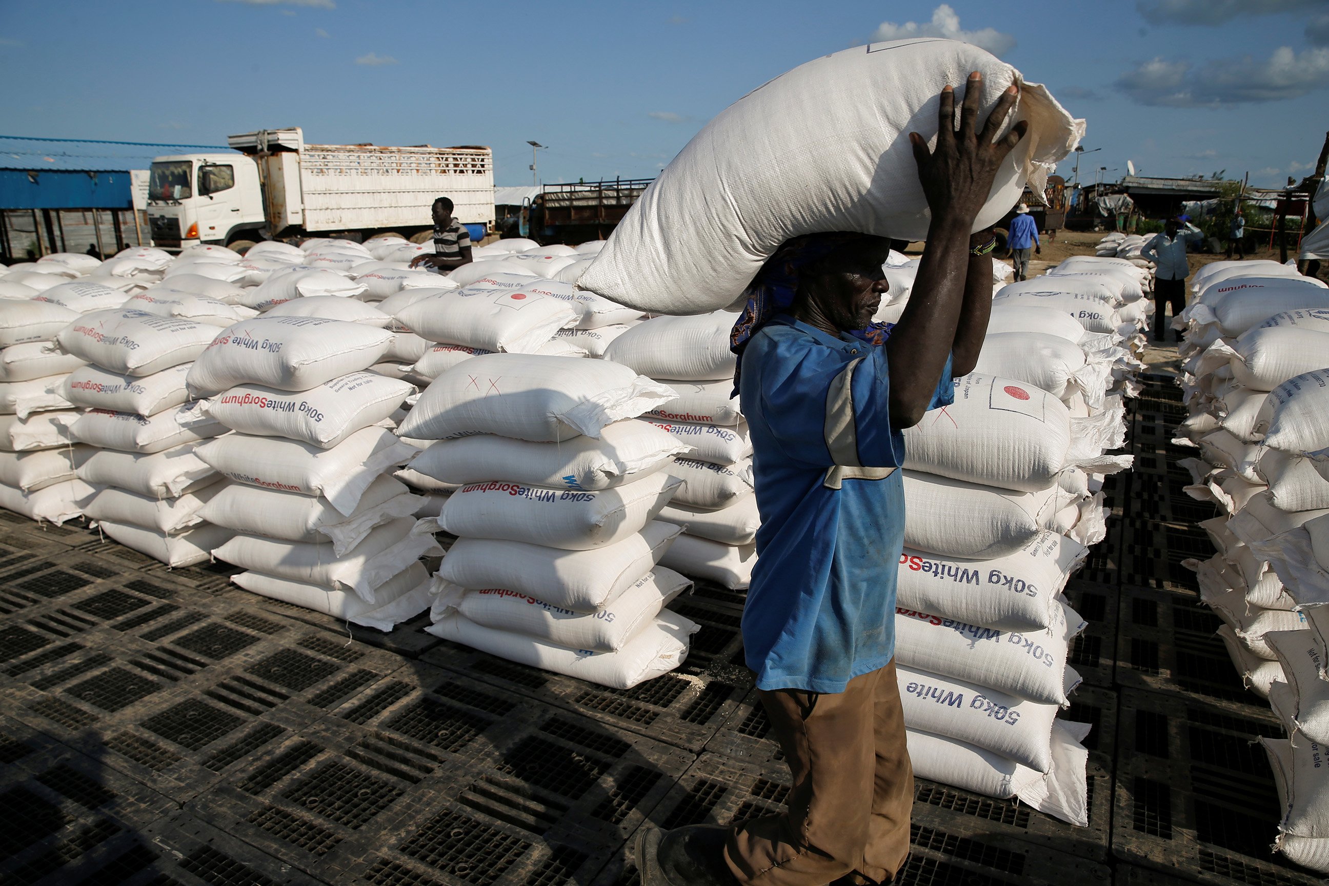 A man carries sacks of food aid for distribution to Internally displaced people (IDPs) in the POC (Protection of Civilians) Camp, run by the UN Mission in South Sudan near the town of Malakal, in the Upper Nile state of South Sudan, September 9, 2018.