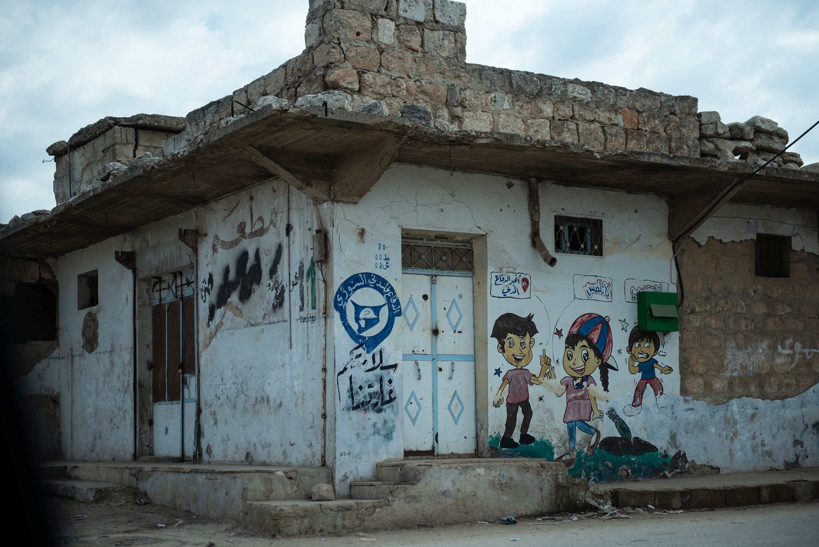Paintings on a wall in the village of al-Nayrab demonstrate what to do if you encounter a potential UXO.