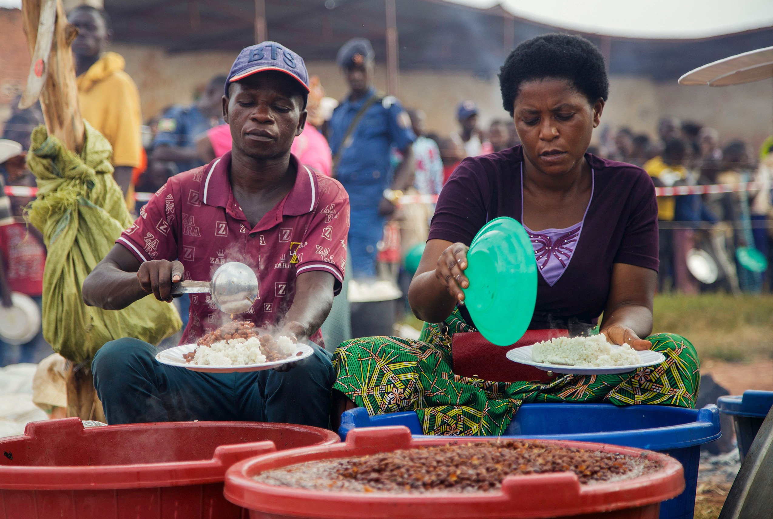 Burundian volunteers serve food to Congolese families at Rugombo Stadium, after Congolese fled from renewed clashes between M23 rebels and the Armed Forces of the Democratic Republic of the Congo (FARDC), in Rugombo commune of Cibitoke Province.