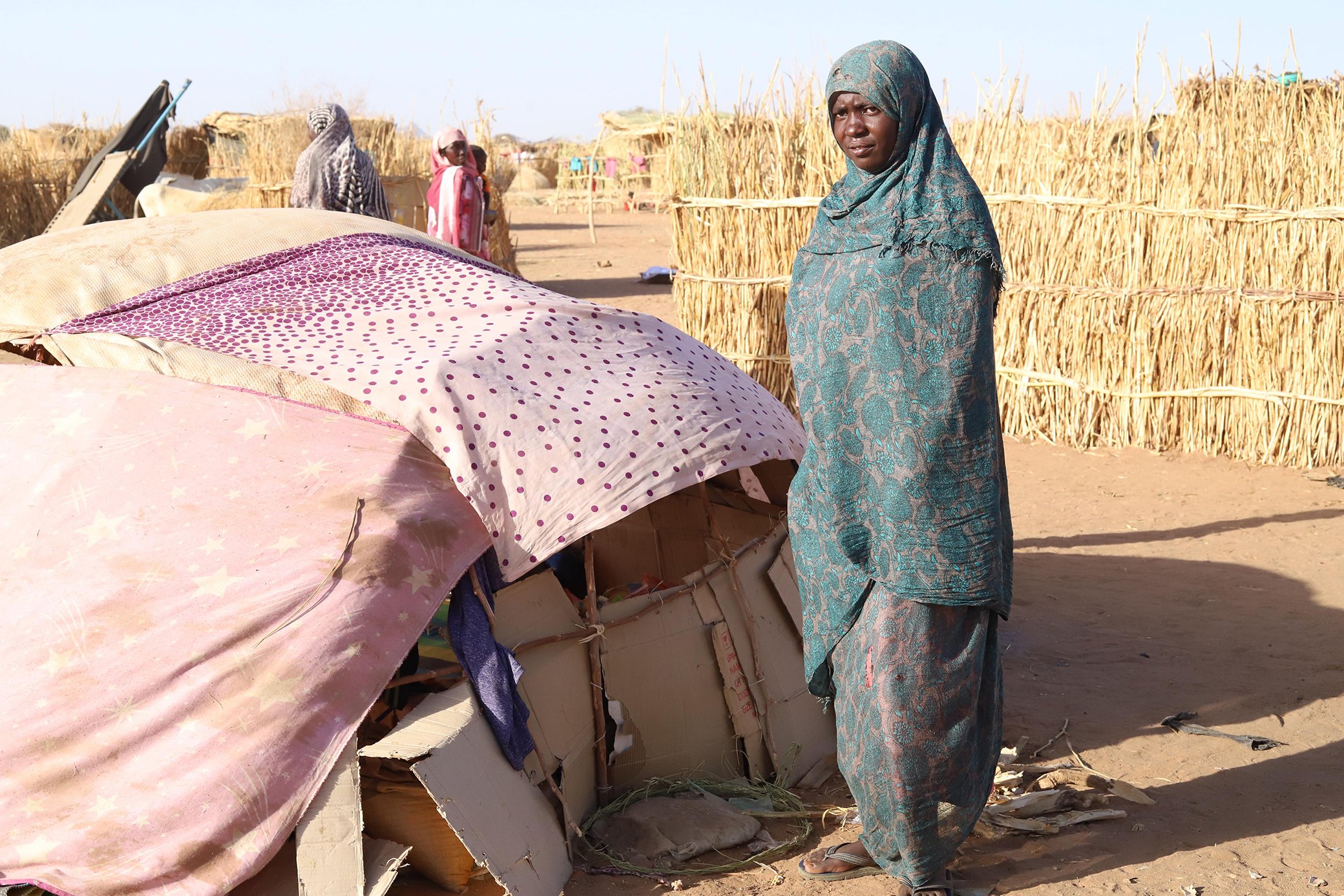 A displaced woman from Zam Zam camp stands beside a makeshift shelter on the outskirts of Tawila, in North Darfur state.