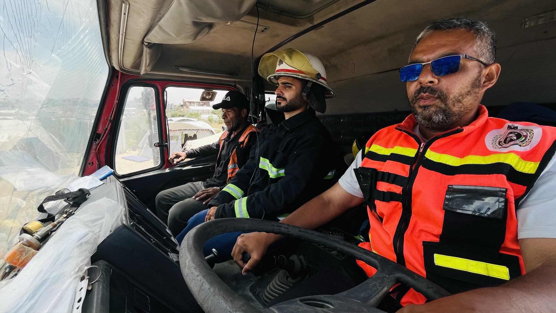 Ahmed Radwan (right), Yasser Amer (centre), Raed Ashour (left) heading out in a firetruck from their base in al-Mawasi to respond to an emergency.