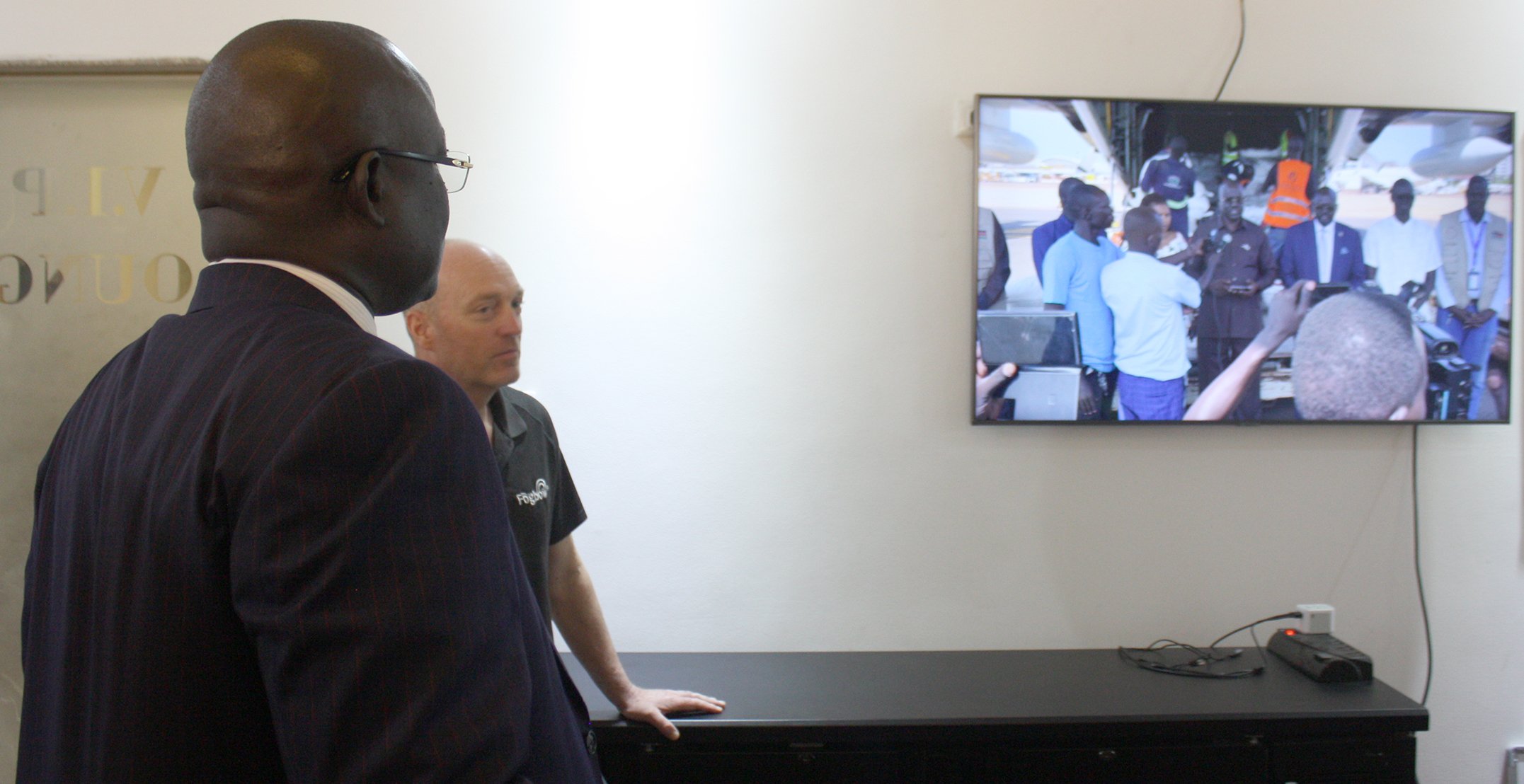 Fogbow’s chief operations officer, Eric Oehlerich, in the background, gives a briefing to South Sudan’s minister of humanitarian affairs, Albino Akol Atak, in the foreground, on the status of food drops, on 10 June 2025.