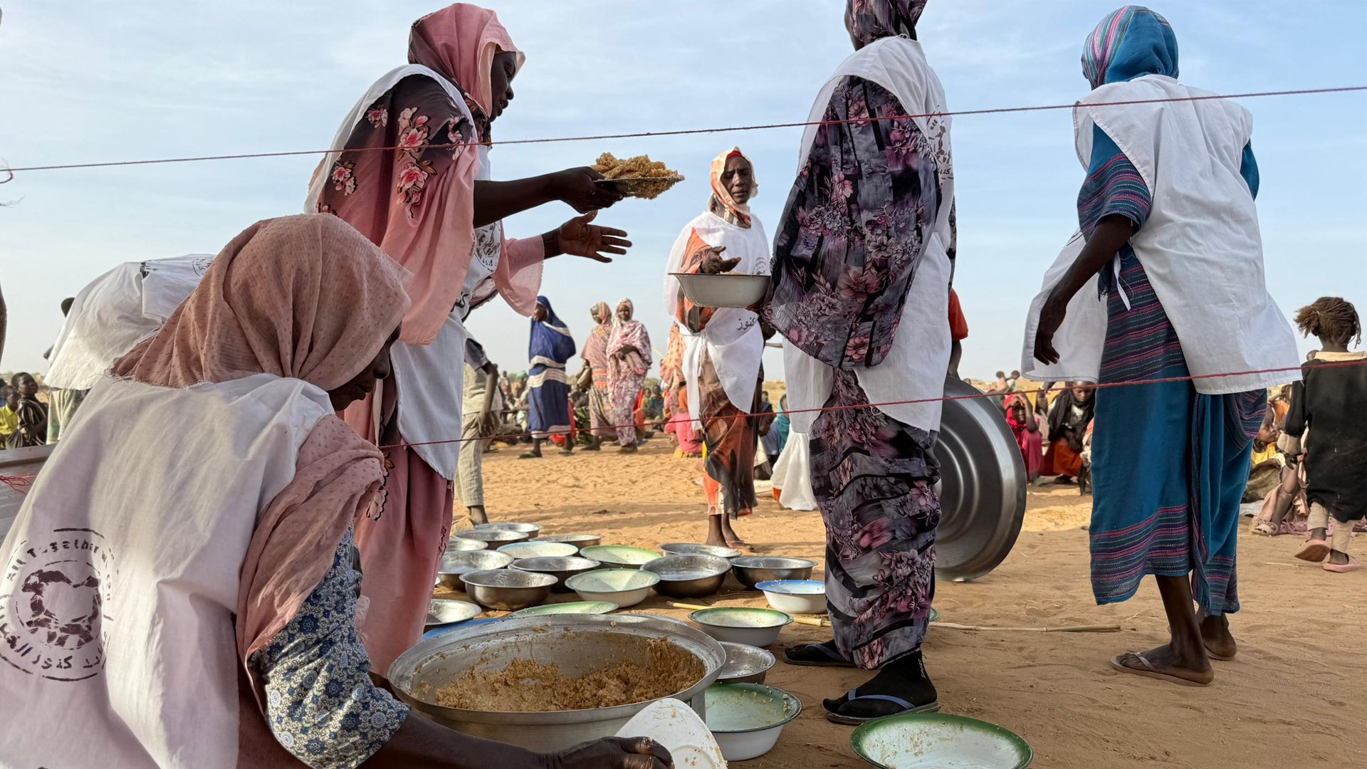 A local community kitchen distributes food to displaced people living in a camp on the outskirts of Tawila.
