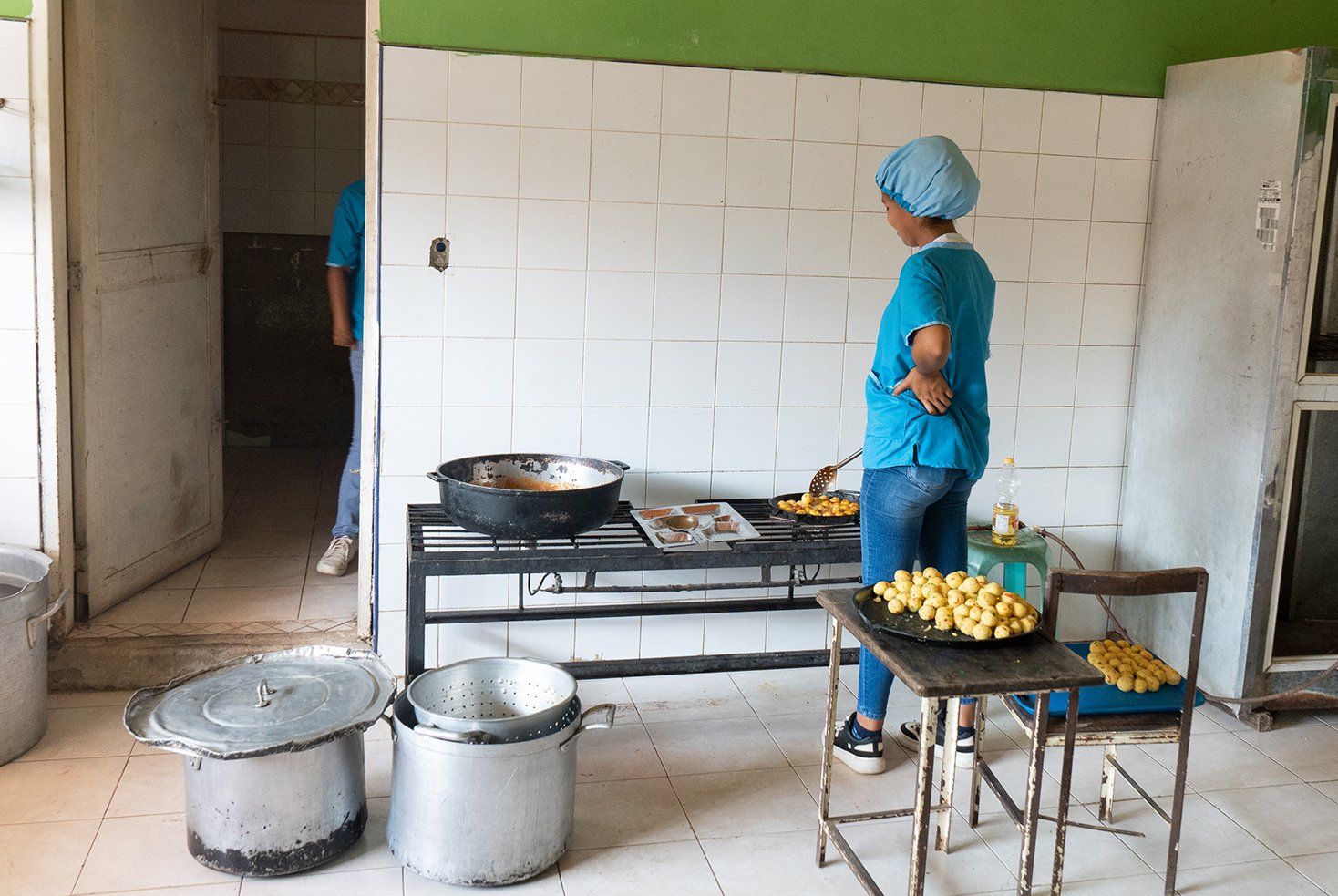 A woman cooks lunch in the Rafael Salazar Brito school in Margarita, but the school is unable to provide food to students every day.