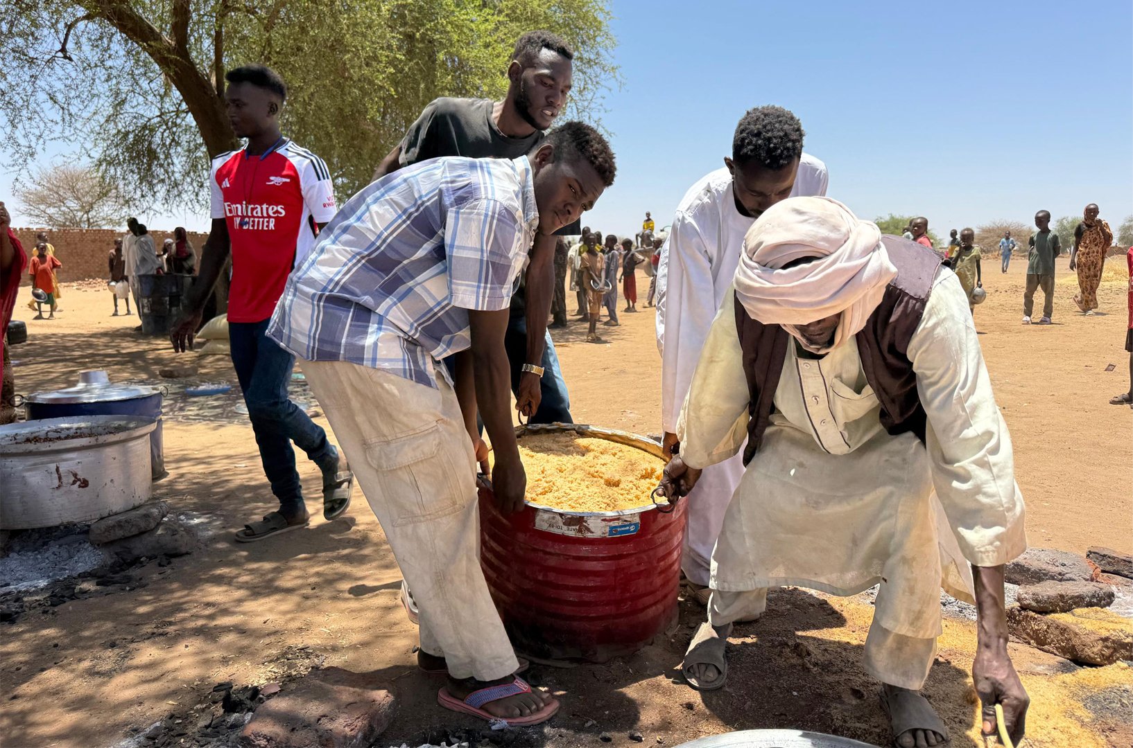 Volunteers from a local initiative carry food to be handed out to displaced families in Tawila, where many are not even eating a single meal per day.