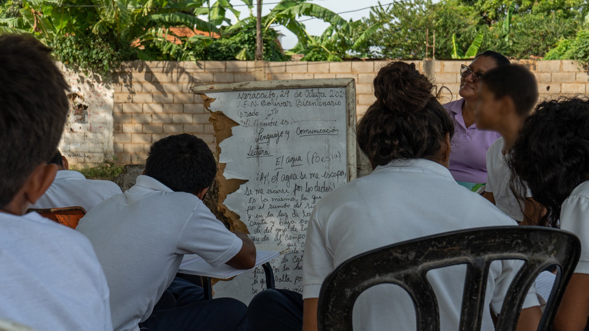 Students, 11 to 12 years old, attend class outdoors in Maracaibo. Despite the lack of material and low salaries, educators continue to give classes.