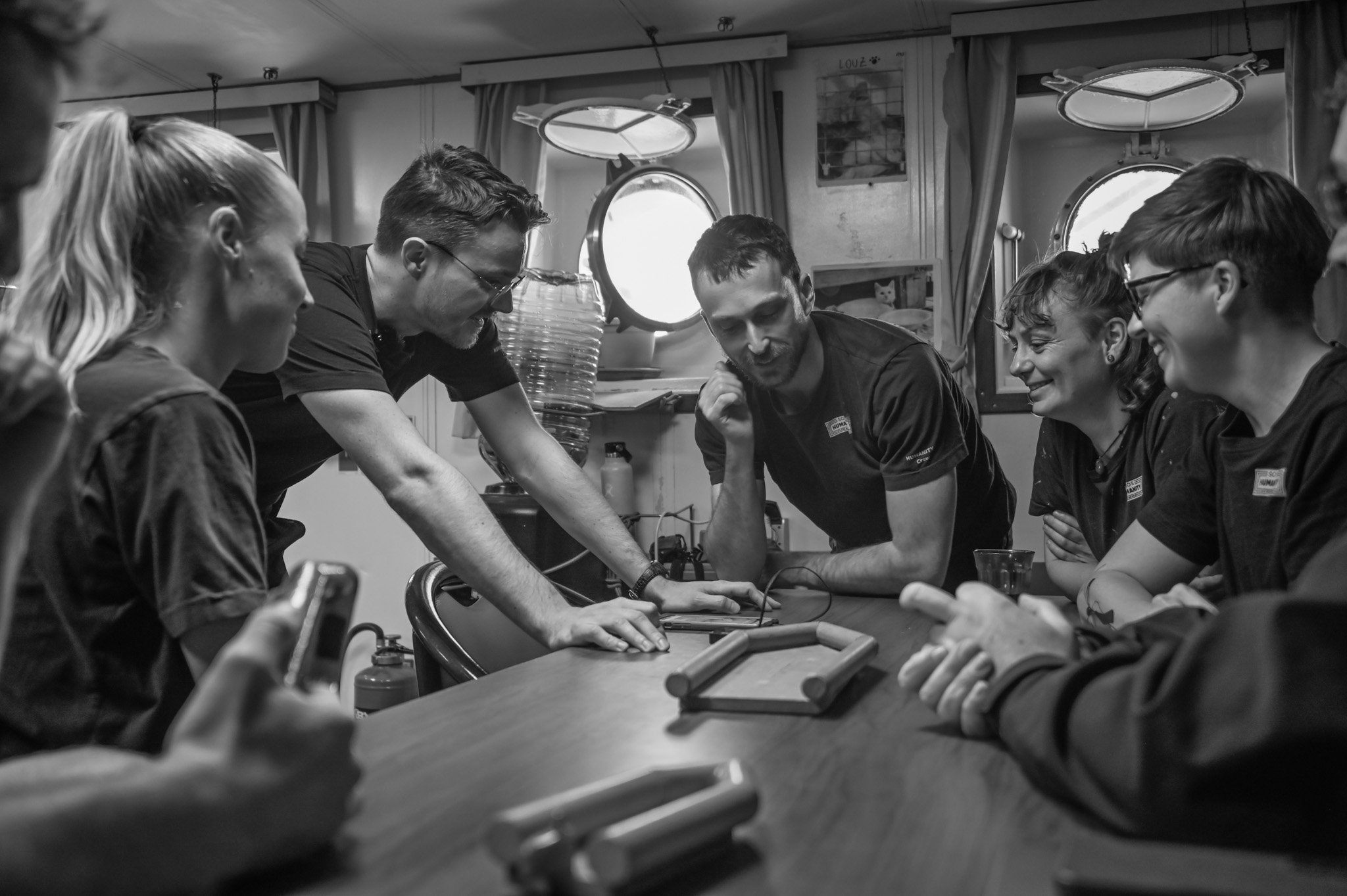 The rescue team discusses tactics with the aid of two wooden model boats.