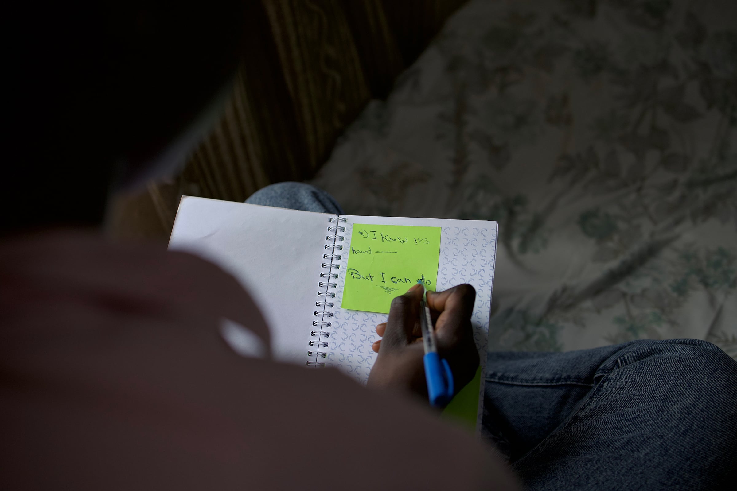 Rayan writes down motivational thoughts in a notebook.