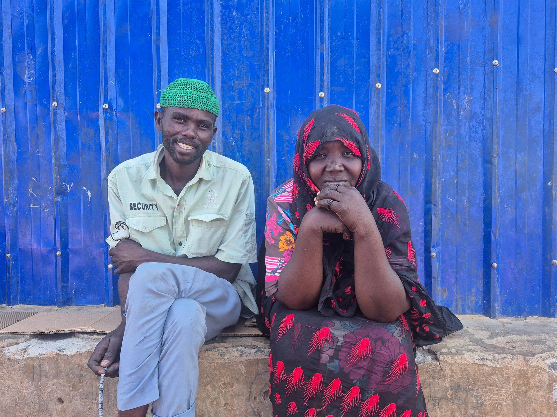 Portrait of a woman and her husband in front of a blue wall
