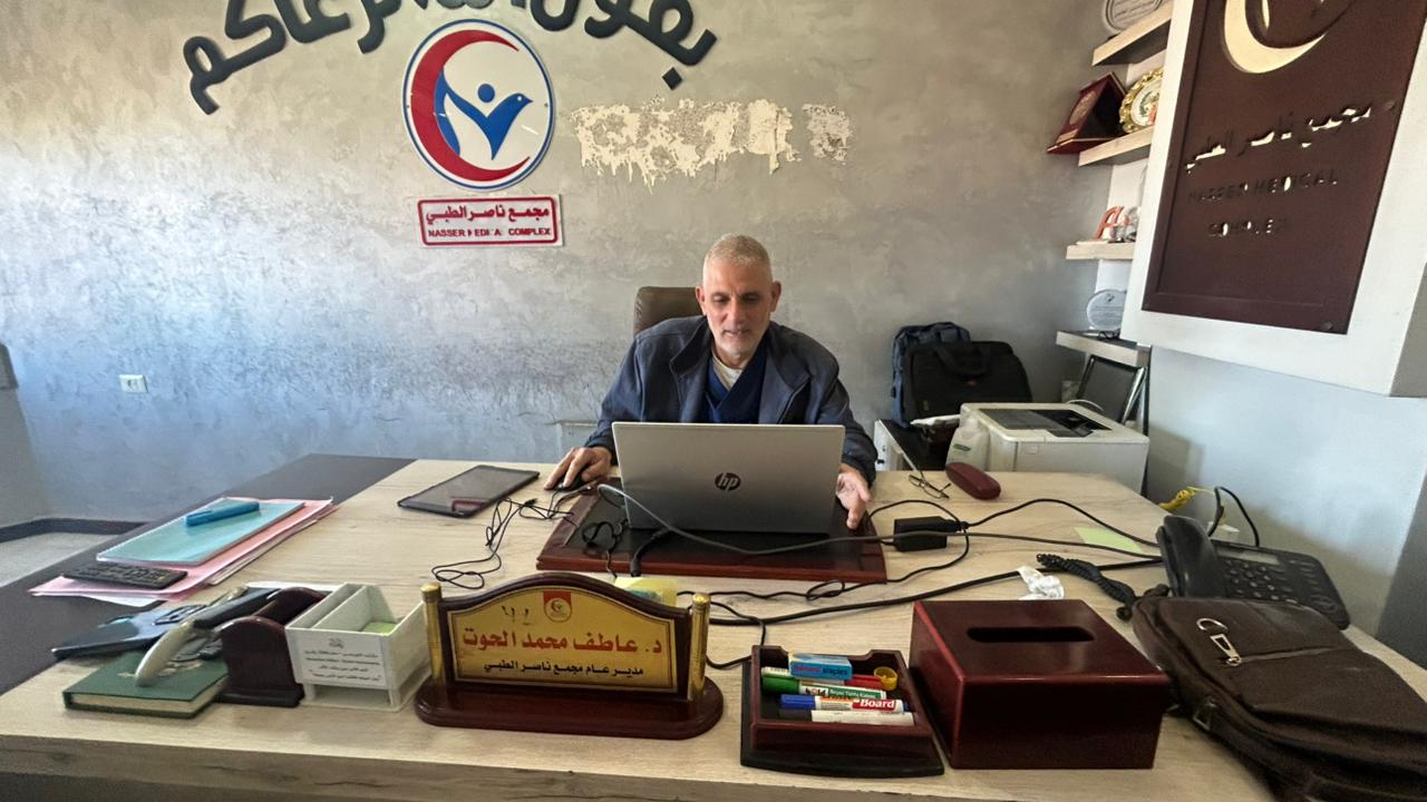 Atef Al-Hout, director of Nasser Medical Complex in Khan Younis, sits at an office table inside the hospital.