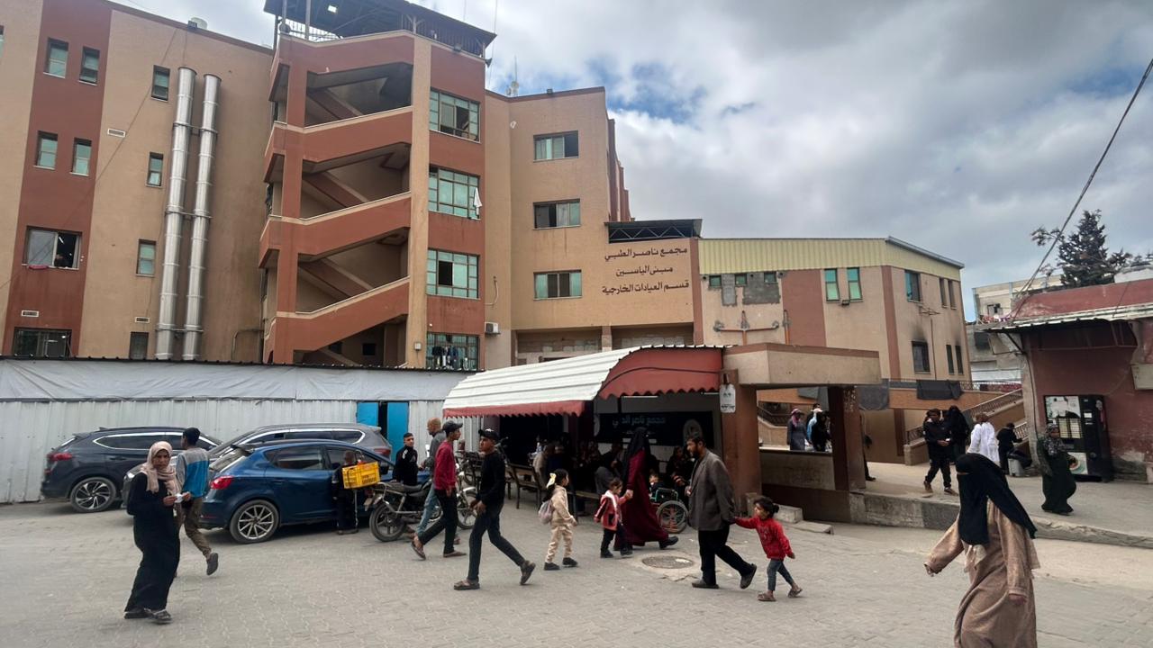 People walk past a building inside Nasser Medical Complex.