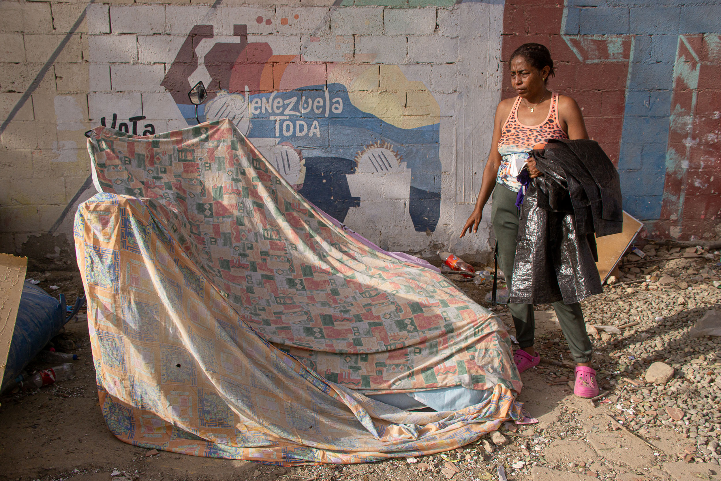 Jenny Mosquera, a resident of La Guaira, watches over the recovered bodies of her husband and her 13-year-old daughter, who died in the 24 June earthquakes.