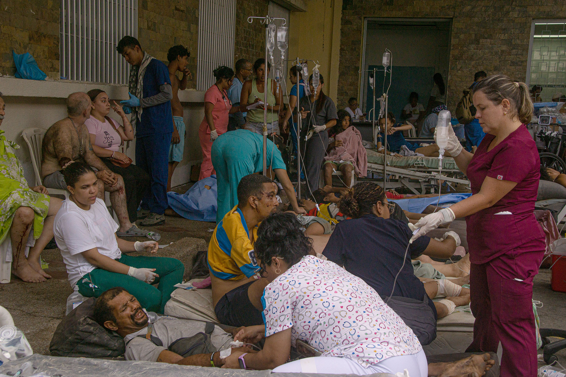 Overwhelmed health workers tend to dozens of patients at the entrance of the José María Vargas Hospital in La Guaira, on 25 June.