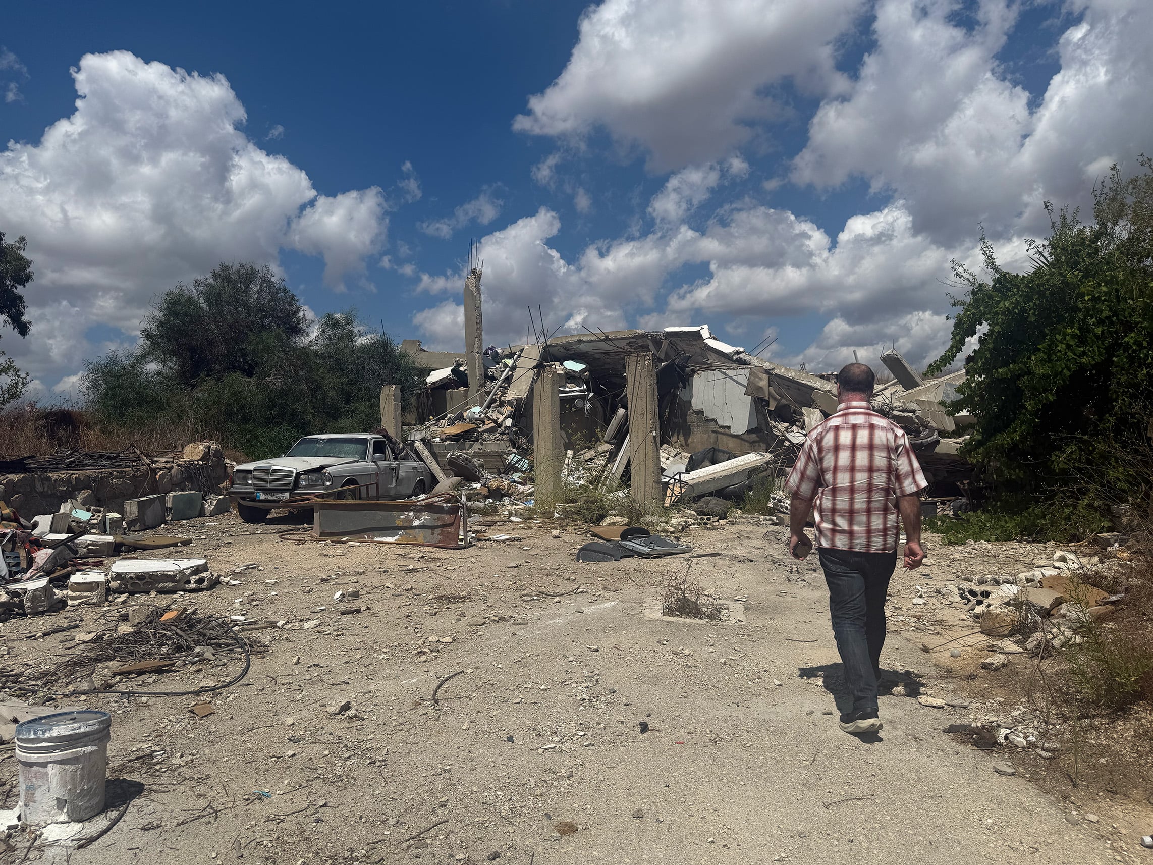 A photo of Najib Farhat walking as he visits his Baarachit home, which was hit by Israel in May 2026.&nbsp;