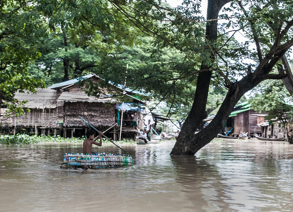 In the village of Sit Pin Gyi in the Irawaddy delta of Myanmar, a boy paddles in boat made from empty bottles after months of persistent flooding.