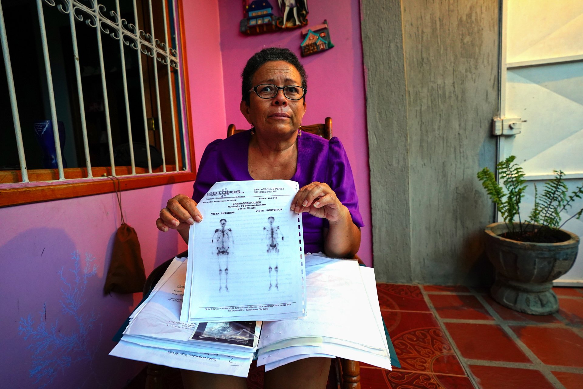 A woman holds up medical files