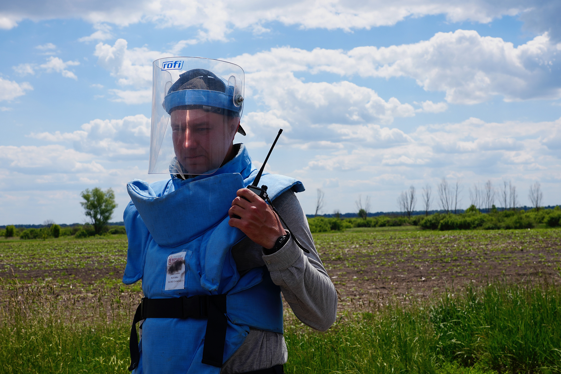 A deminer with the Danish Refugee Council speaks on the walkie talkie near a village in the Chernihiv region.