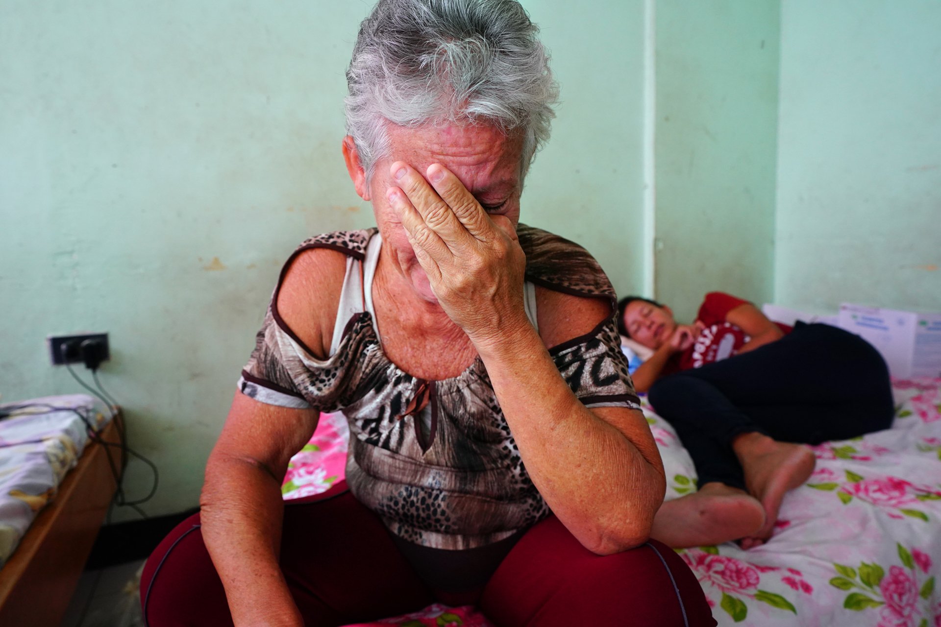 A woman with her hand covering her crying