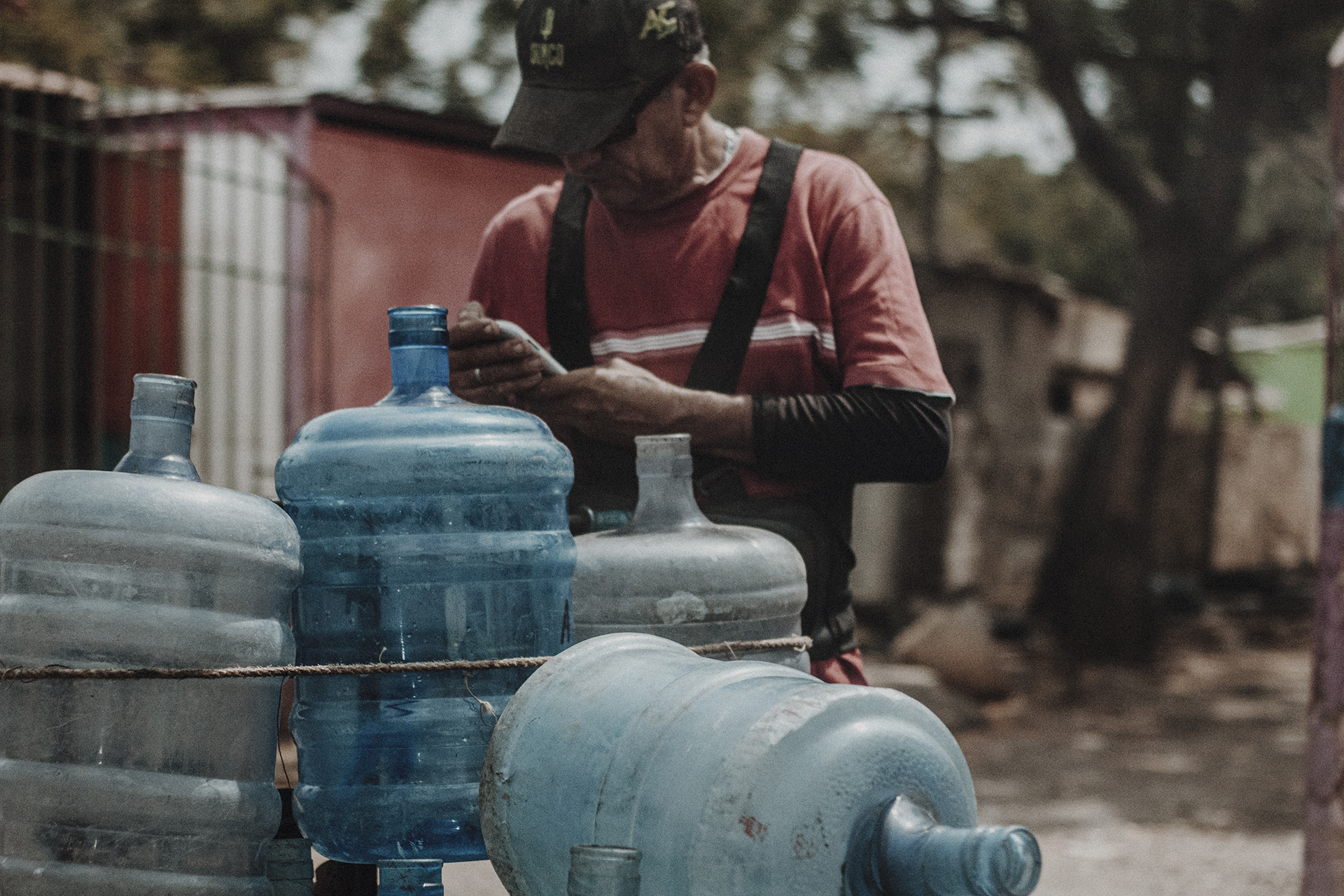 Man loading bottles to start searching the streets for water. This could take hours.