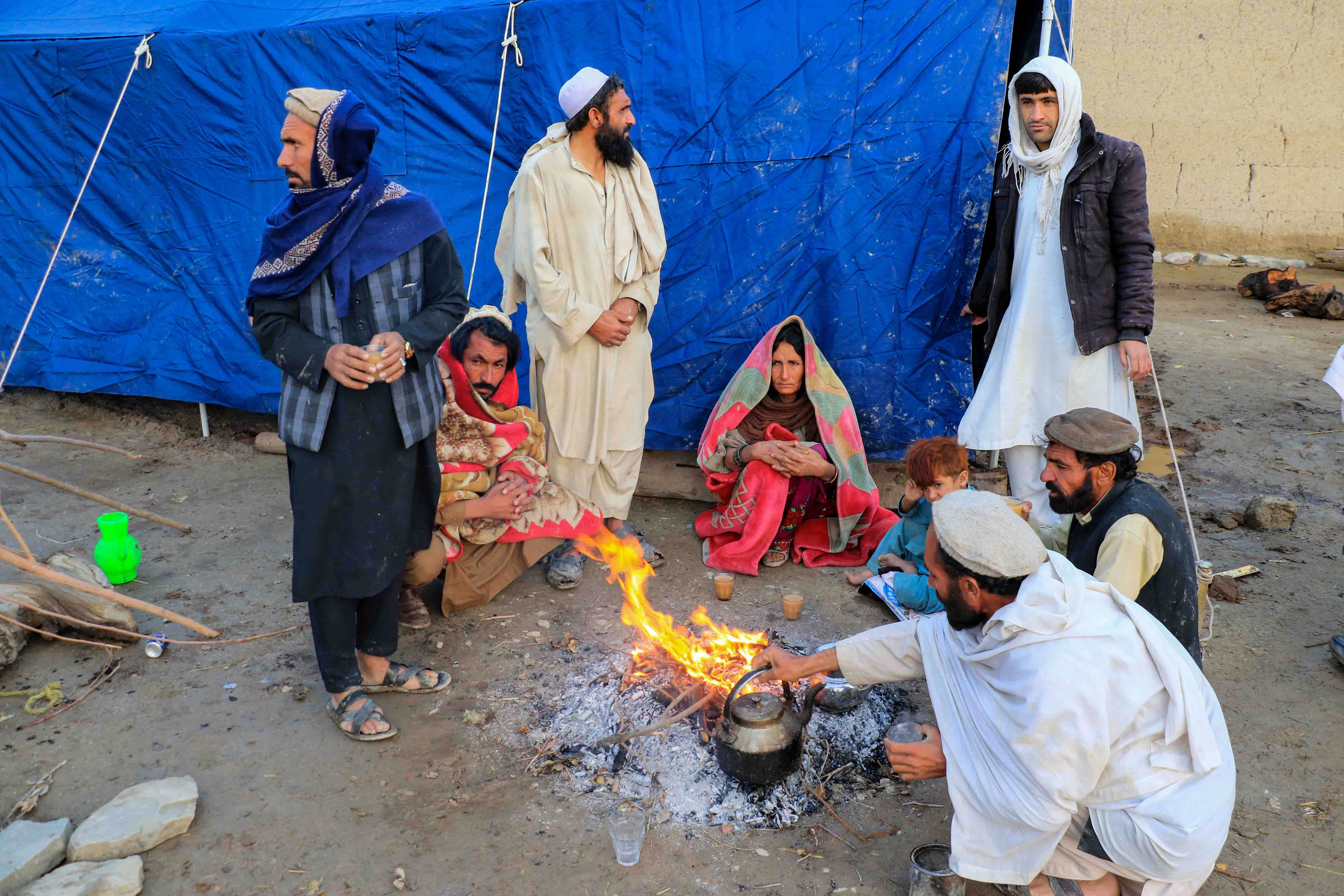 Villagers in Ochlakai in Gayan district sit outside the remains of their damaged home. Since the earthquake, they have been staying in a tent.