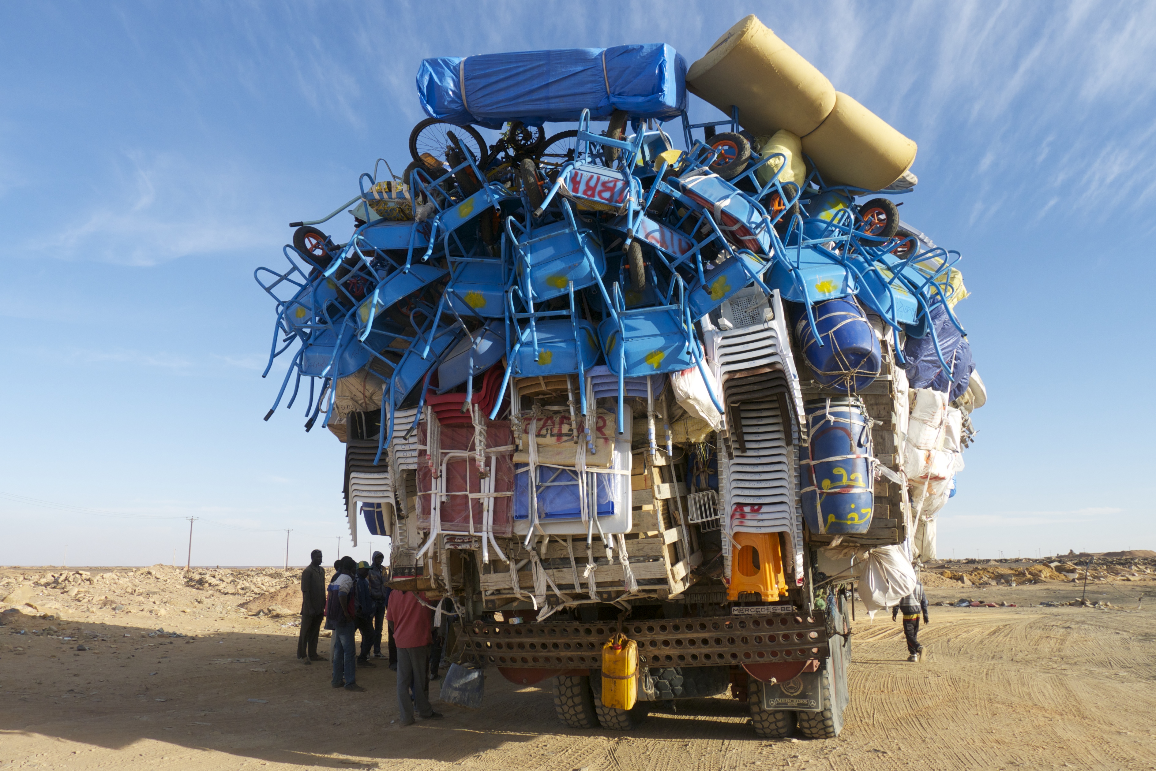 Trucks with chairs hanging off the back and migrants inside Truck with chairs hanging off the back