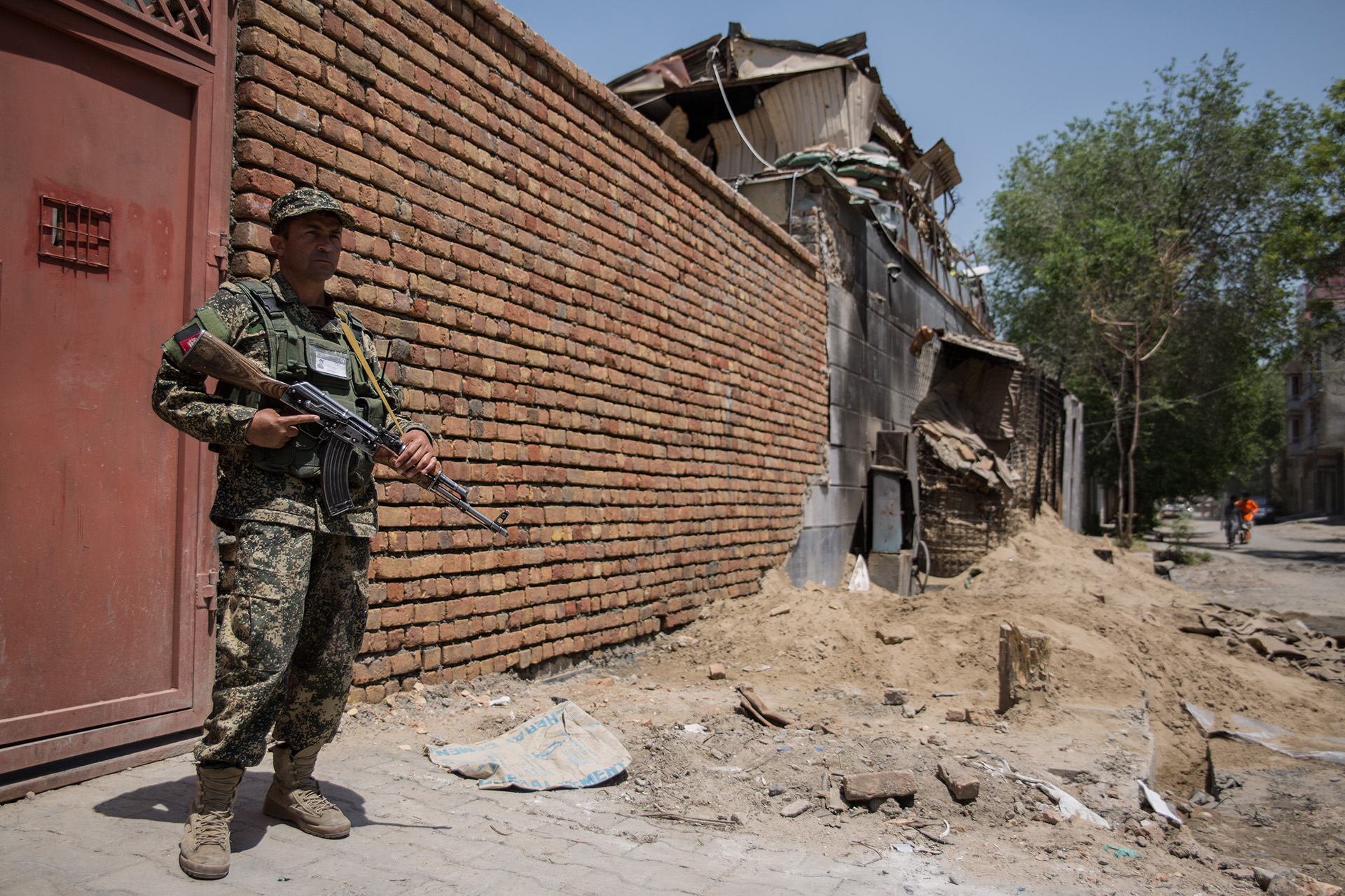 A guard stands outside the Kabul compound of Counterpart International following a Taliban-claimed attack.