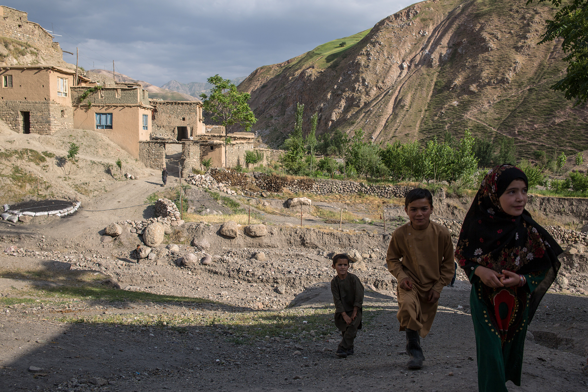 Children walk in an arid mountain village.