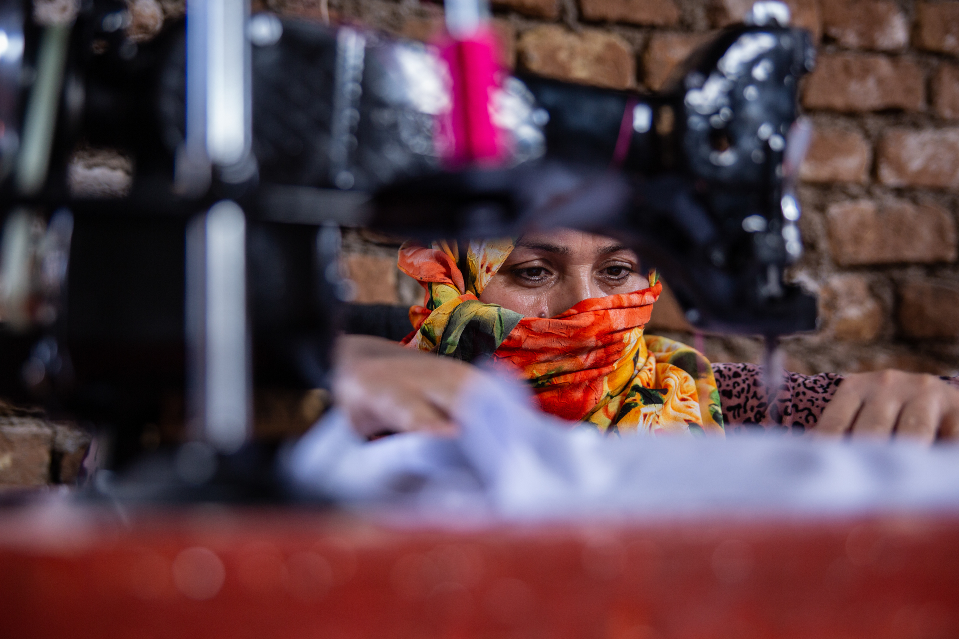 A woman in Afghanistan sits behind a sewing machine