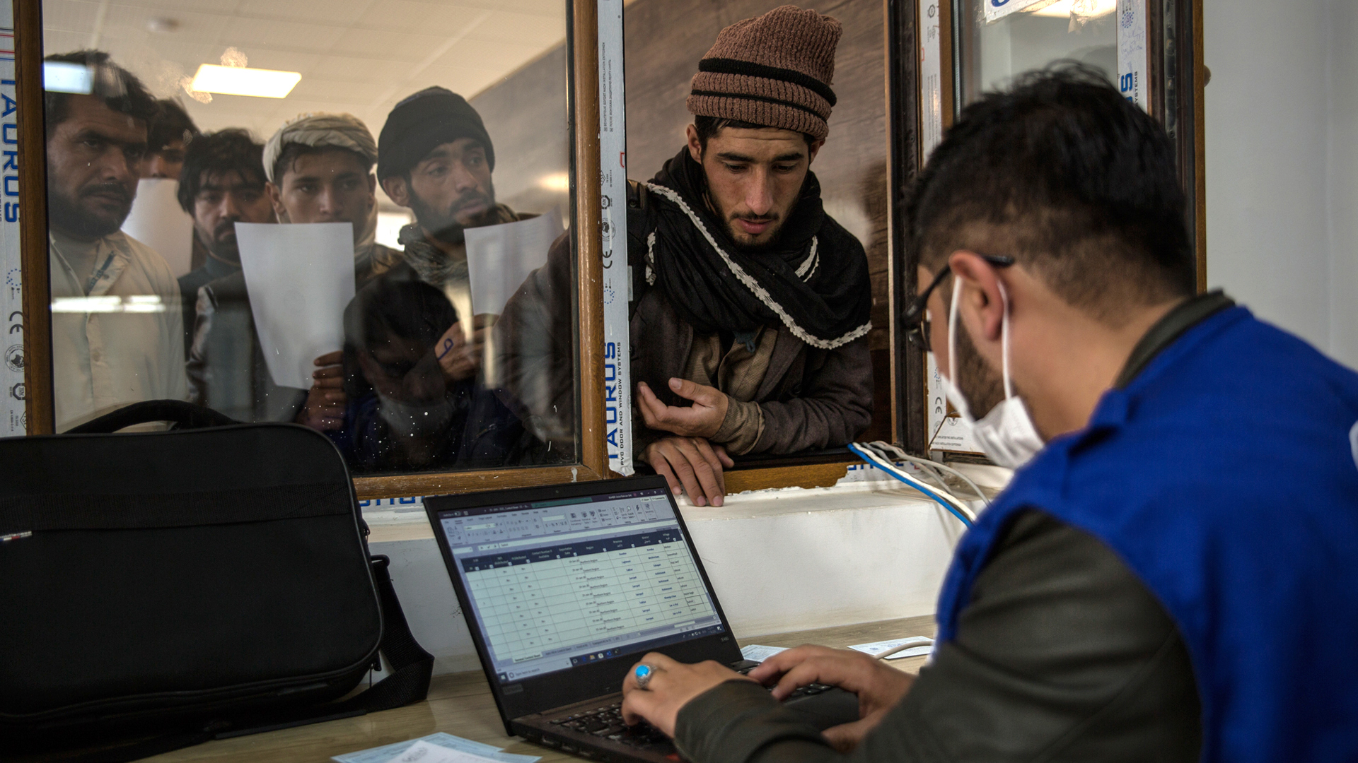 An IOM staff member registers newly arrived returnees at the border reception centre.