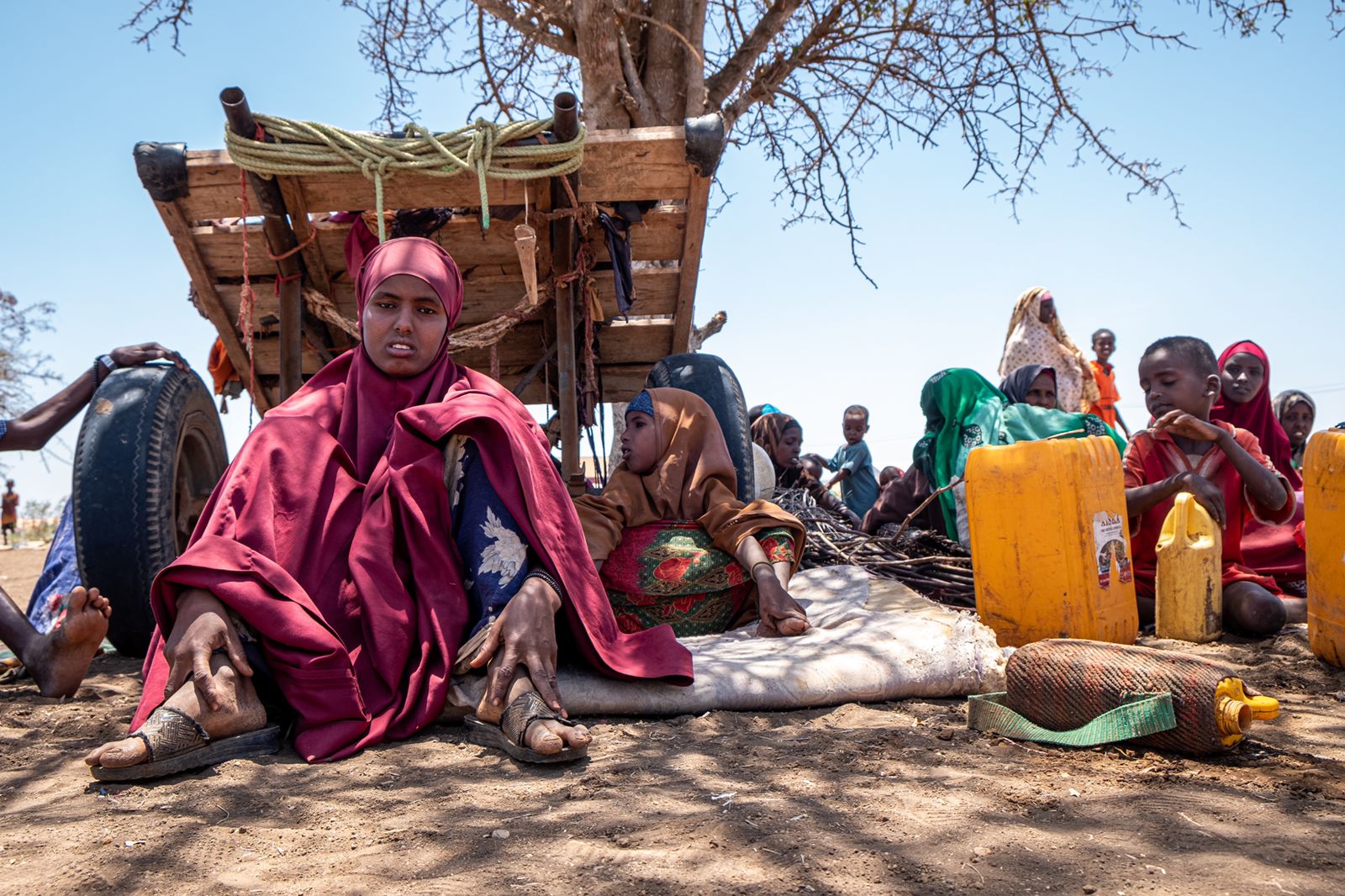 In the town of Baidoa, in central Somalia, newly arrived people wait outside a displacement camp before being given space to build a makeshift shelter.