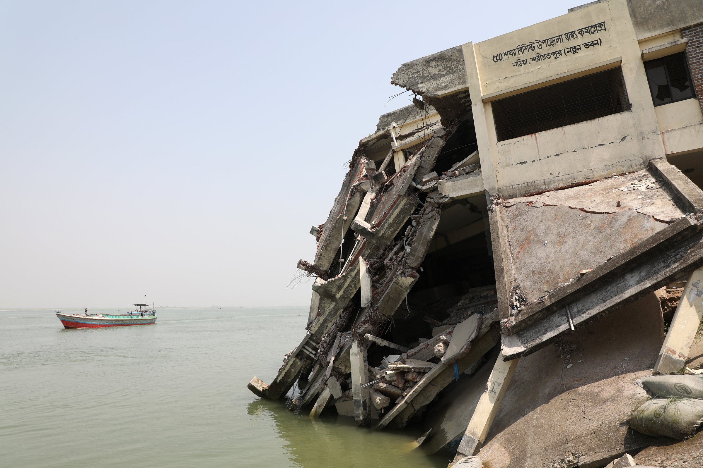 Photo of a building that has fallen into the river due to erosion in Bangladesh