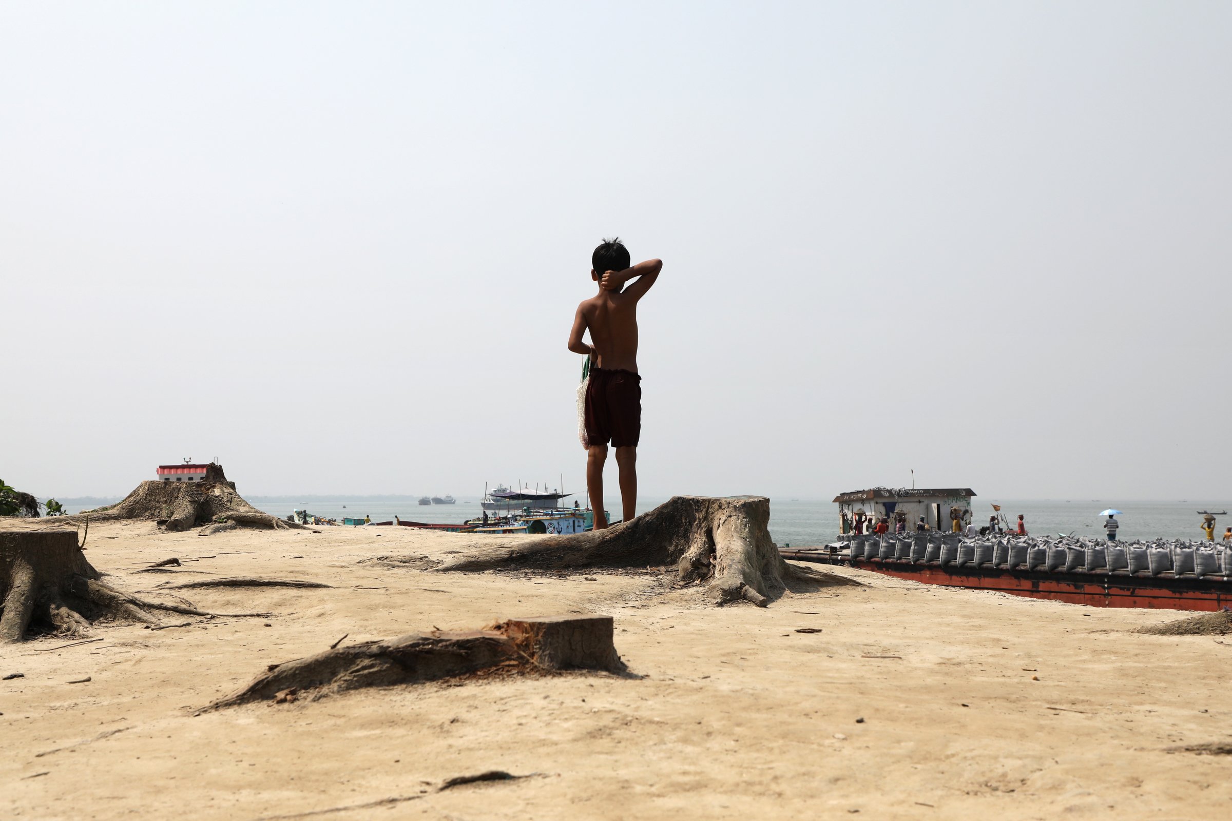 Photo of a child looking out at the Padma river in Bangladesh as river protection work happens