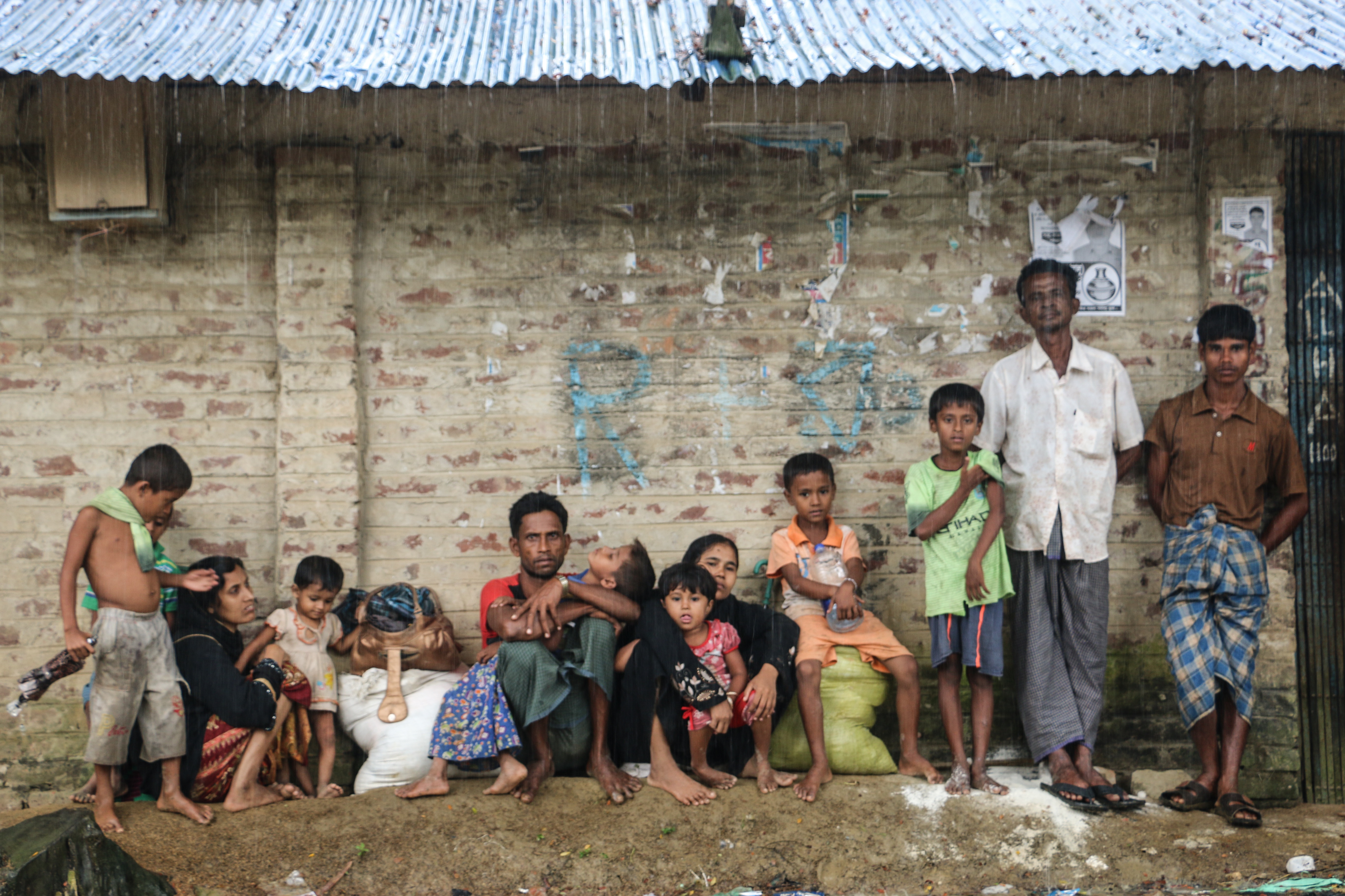 Rohingya refugees take shelter from the rain in Cox's Bazar, Bangladesh.