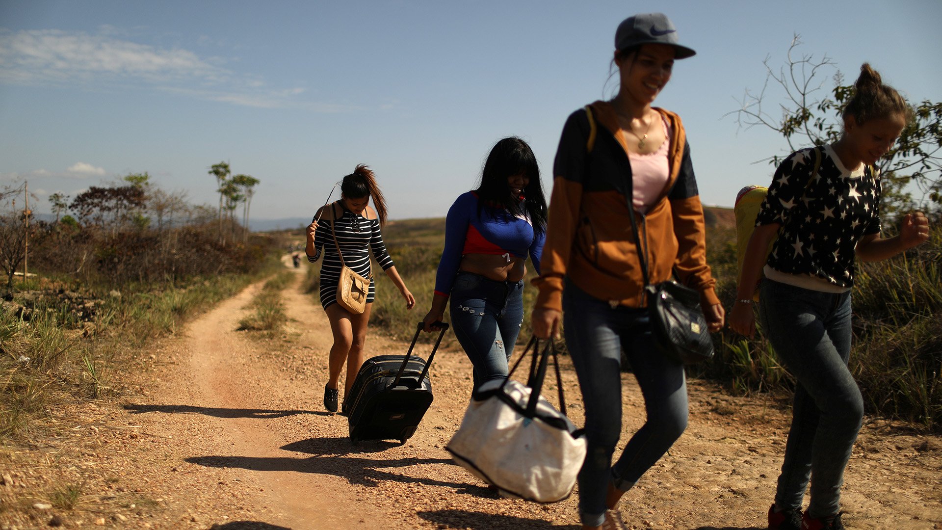 Venezuelan migrants walk along a trail