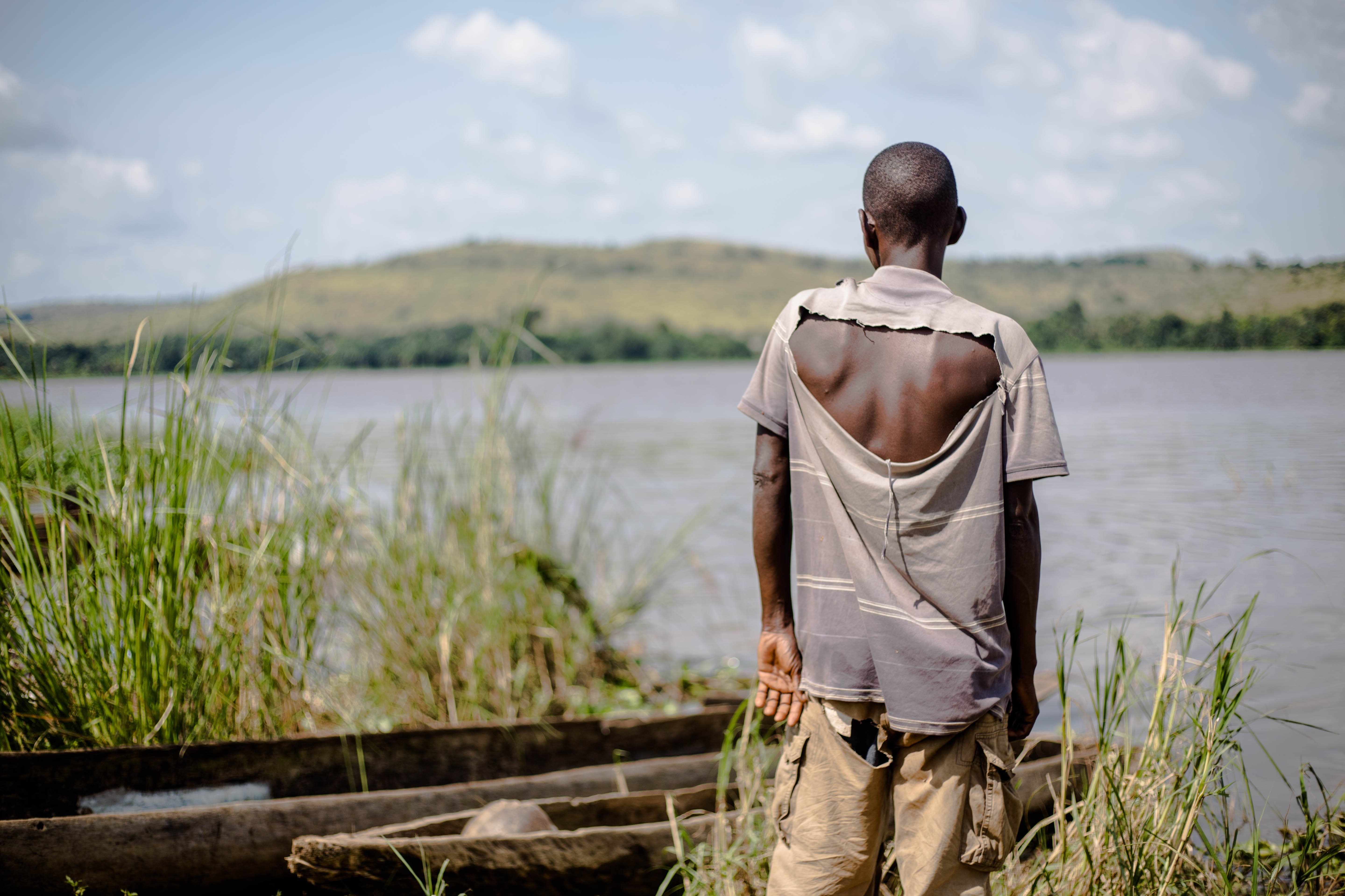 Fabrice Nzongba stares across the river to the village of Mobaye, where his son was killed